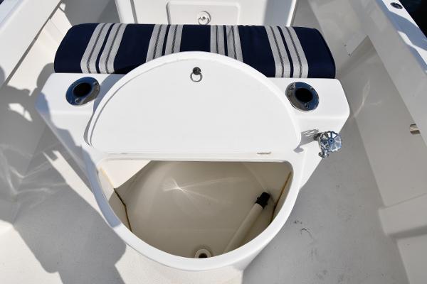 2021 Eastern 248 Center Console boat with open storage compartment and striped cushion.