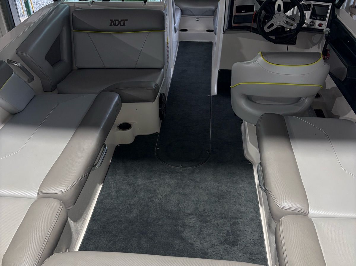 Interior of a 2017 MasterCraft NXT22 boat with gray upholstery and a helm station.