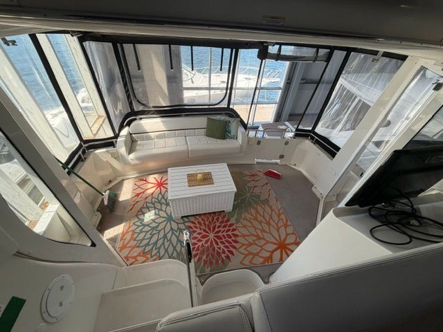 Interior of a 2005 Carver 44 Cockpit Motor Yacht with white seating and colorful rug.