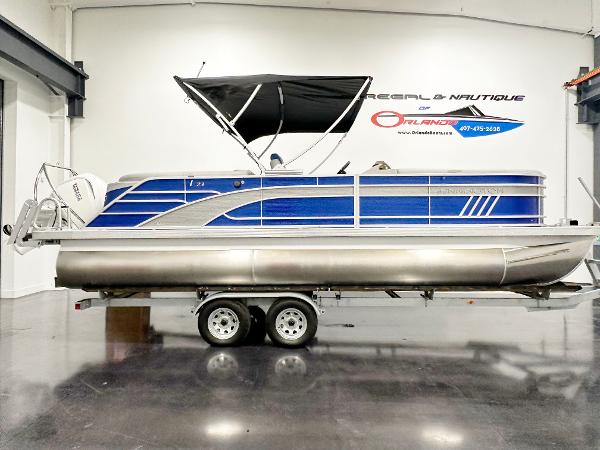 2025 Bennington 23LFBCSR pontoon boat with blue exterior and black canopy on trailer.