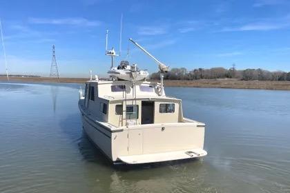 1997 Rosborough Trawler on calm water under clear blue sky.