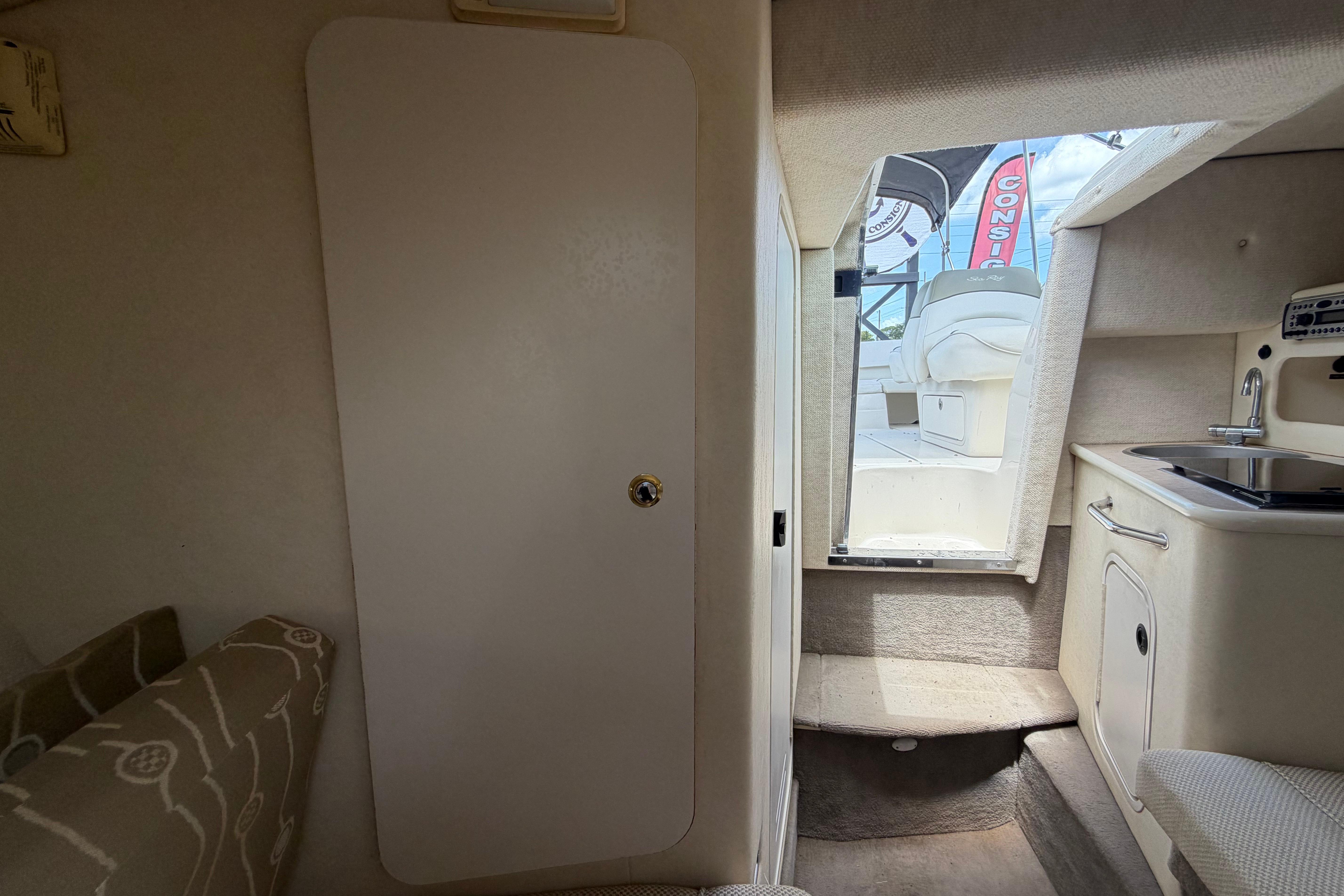 Interior view of 2006 Sea Ray 250 Amberjack boat cabin with kitchenette and seating.