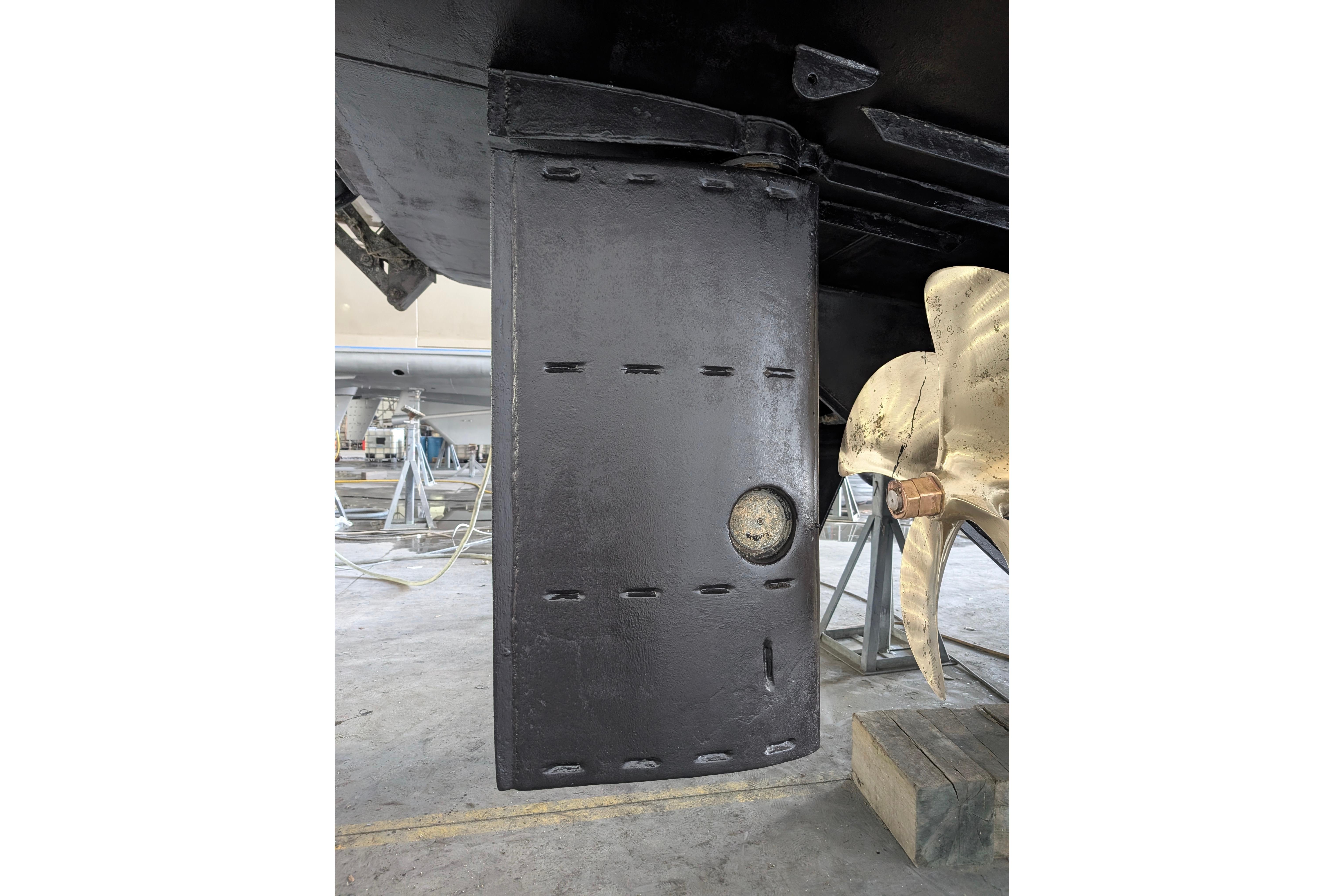 Close-up of a 2001 Doggersbank yacht rudder and propeller in a shipyard.