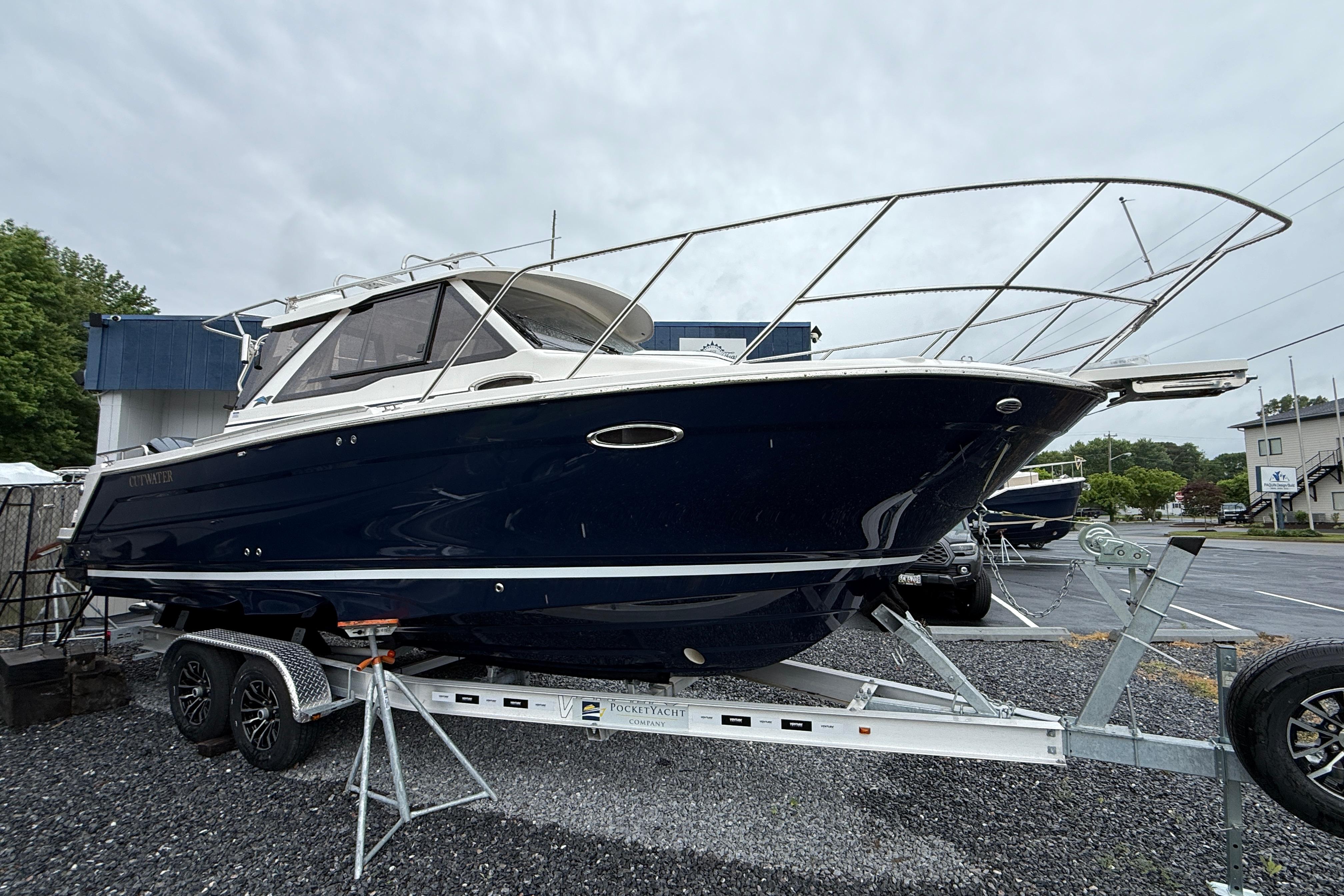 2026 Cutwater C-248 Coupe boat on trailer, parked outdoors on gravel.
