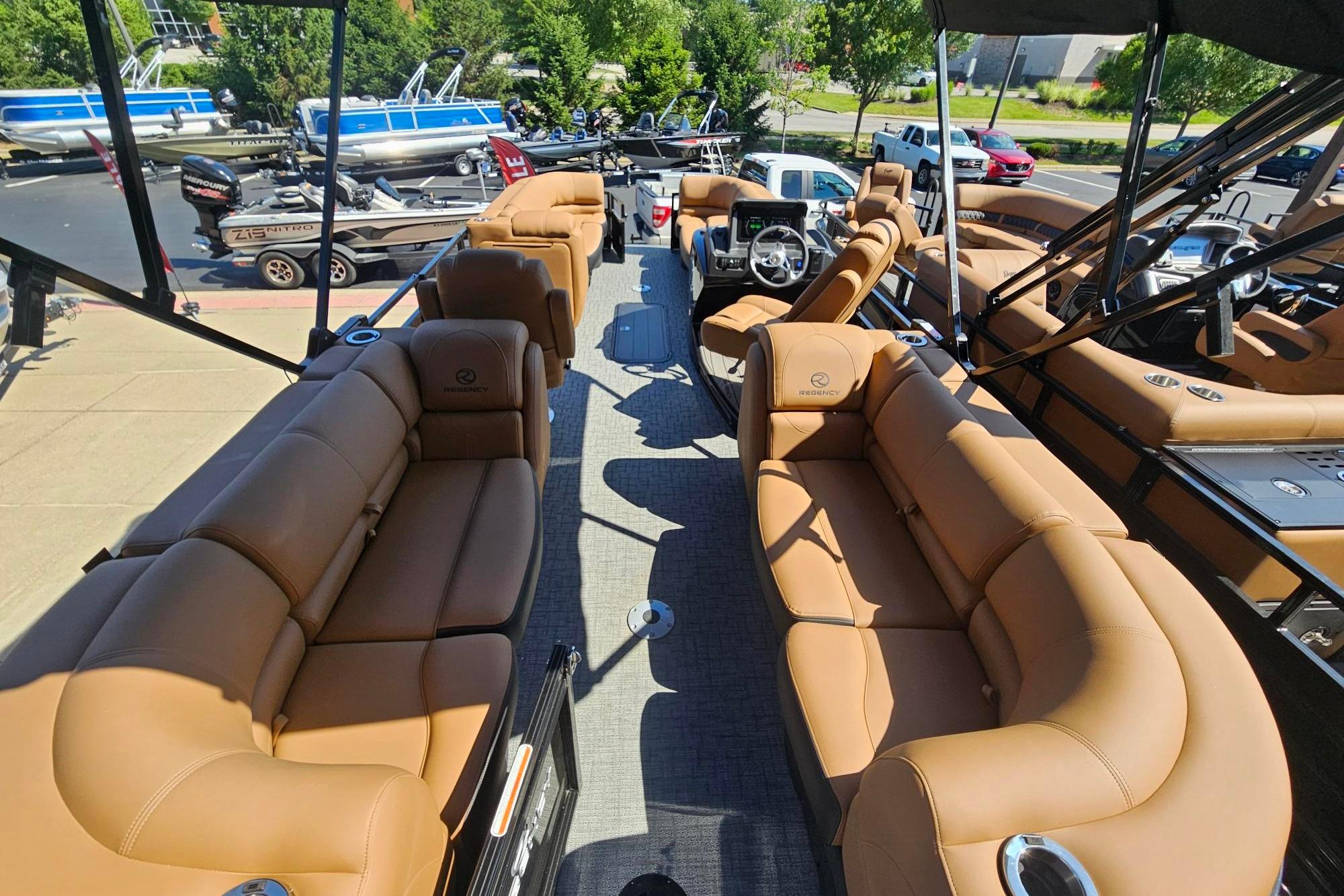 Luxurious 2026 Regency 230 DL pontoon boat with spacious tan seating and modern design.