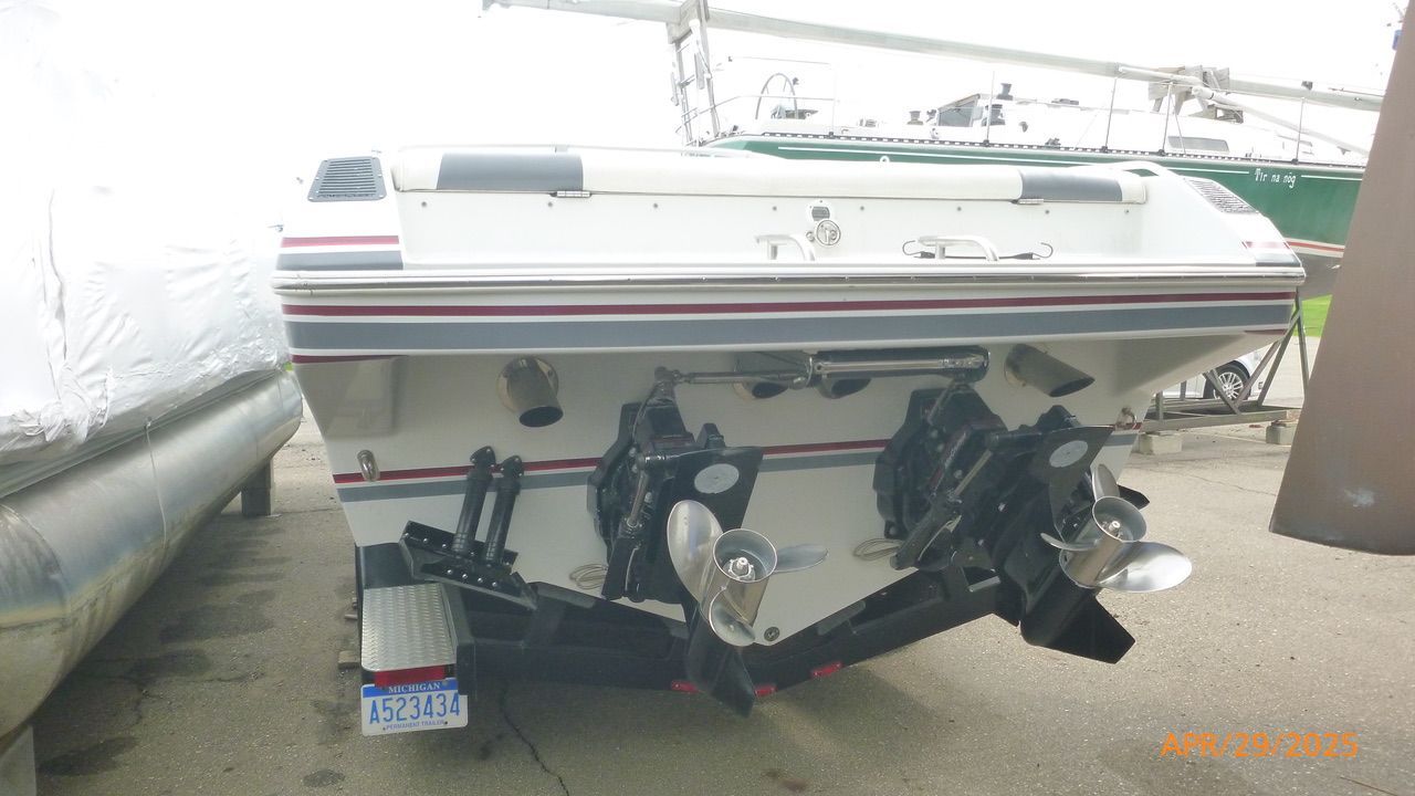 Rear view of a Powerquest 270 Laser boat with dual propellers, parked on a lot.