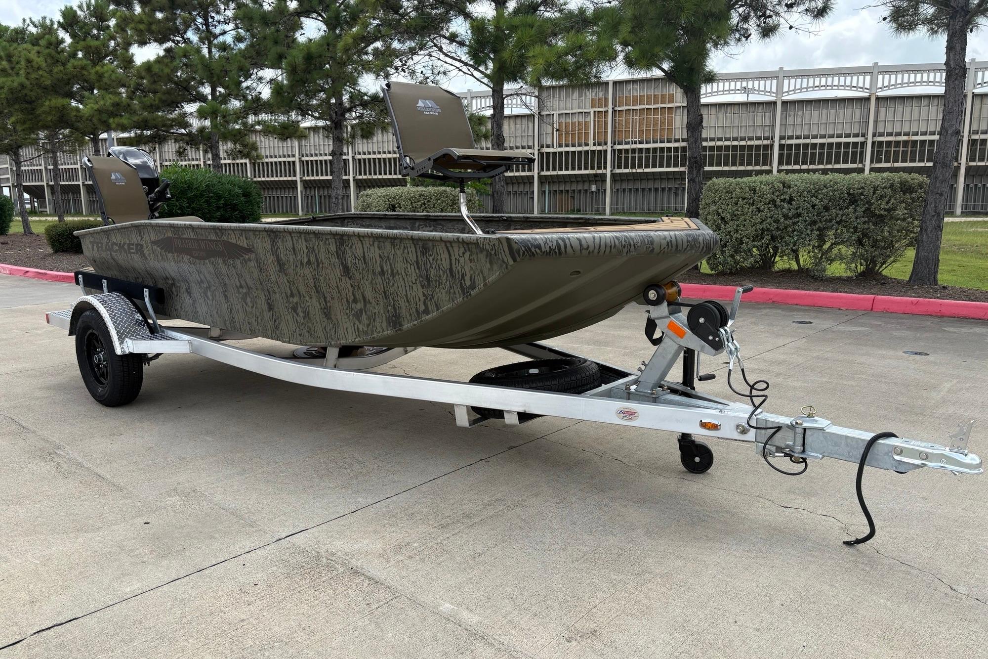 2026 Tracker Grizzly 1650 T Prairie Wings Edition boat on trailer, parked outdoors.