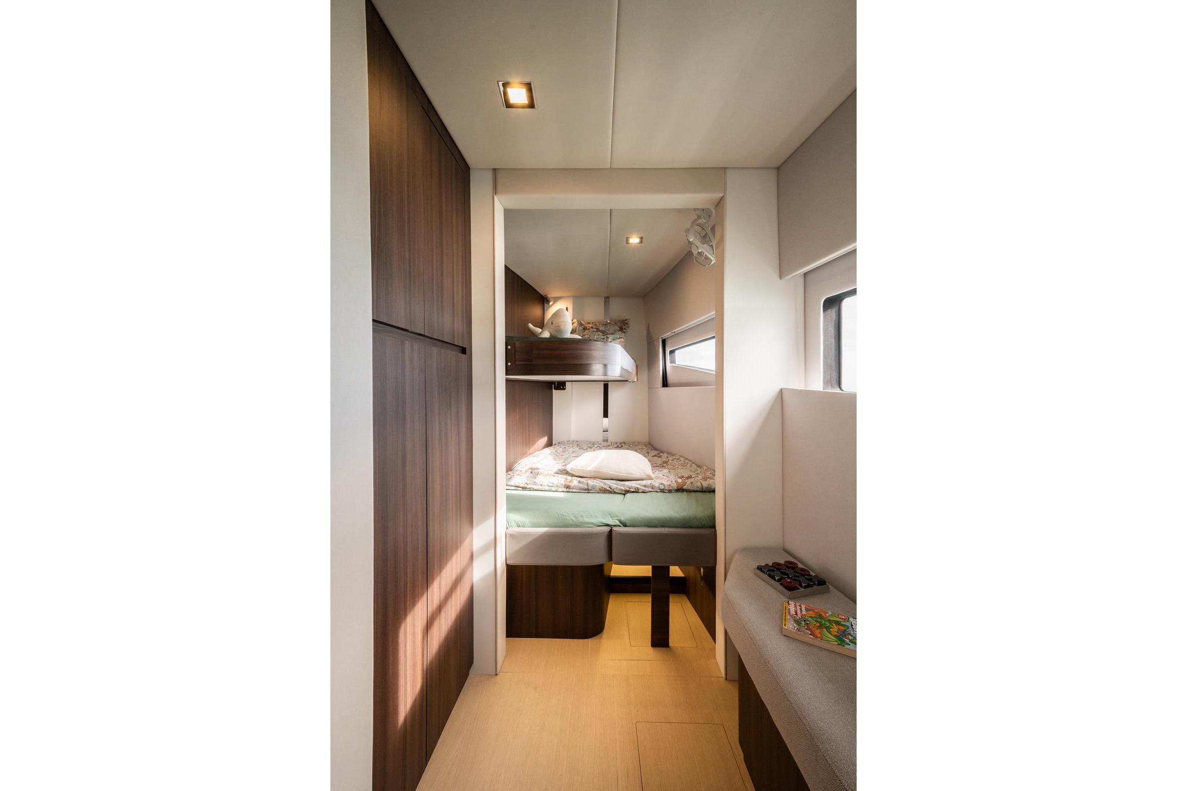Modern Catana OC2 2026 yacht cabin with bunk beds and sleek wooden finishes.