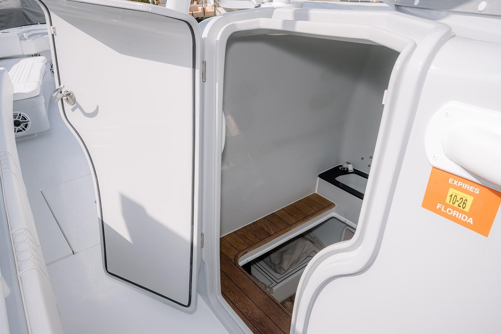 2024 Contender 44 ST boat interior with open cabin door, wooden flooring, and Florida registration sticker.