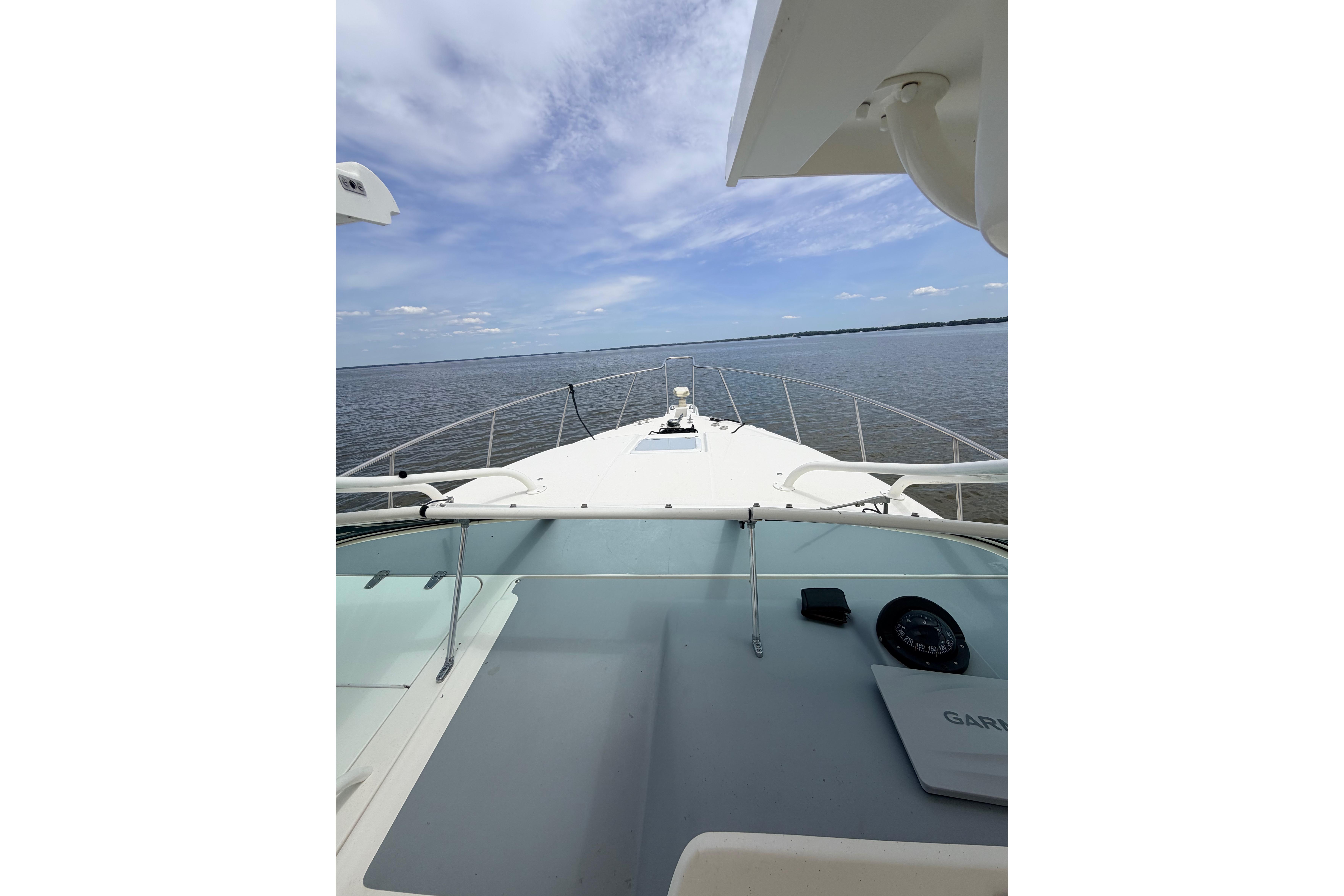 2015 Wellcraft 290 Coastal boat deck with ocean view under blue sky.