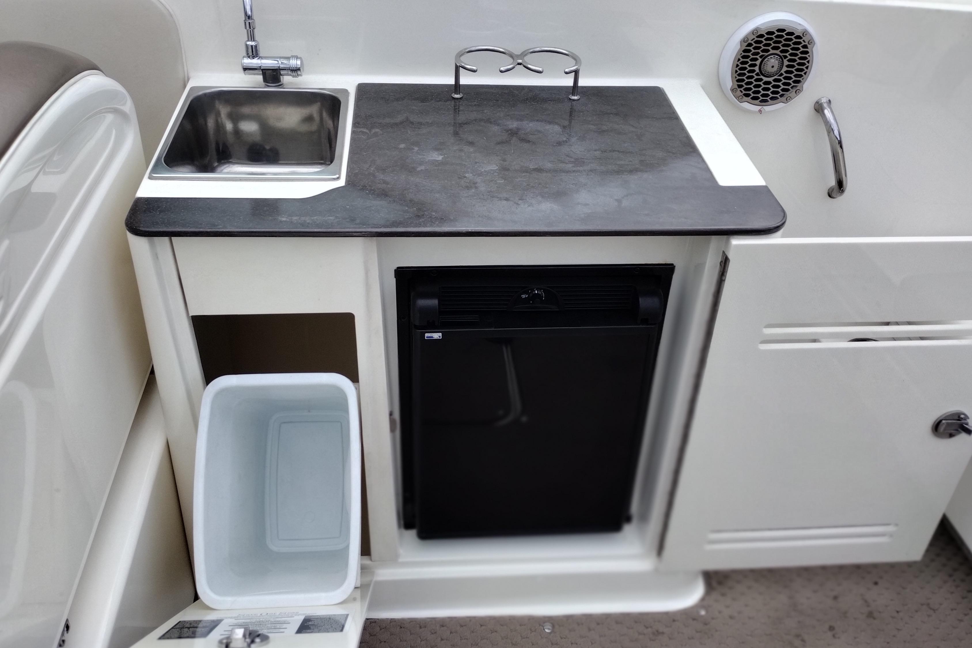 2013 Sea Ray 300 SLX boat kitchenette with sink, countertop, and mini fridge.