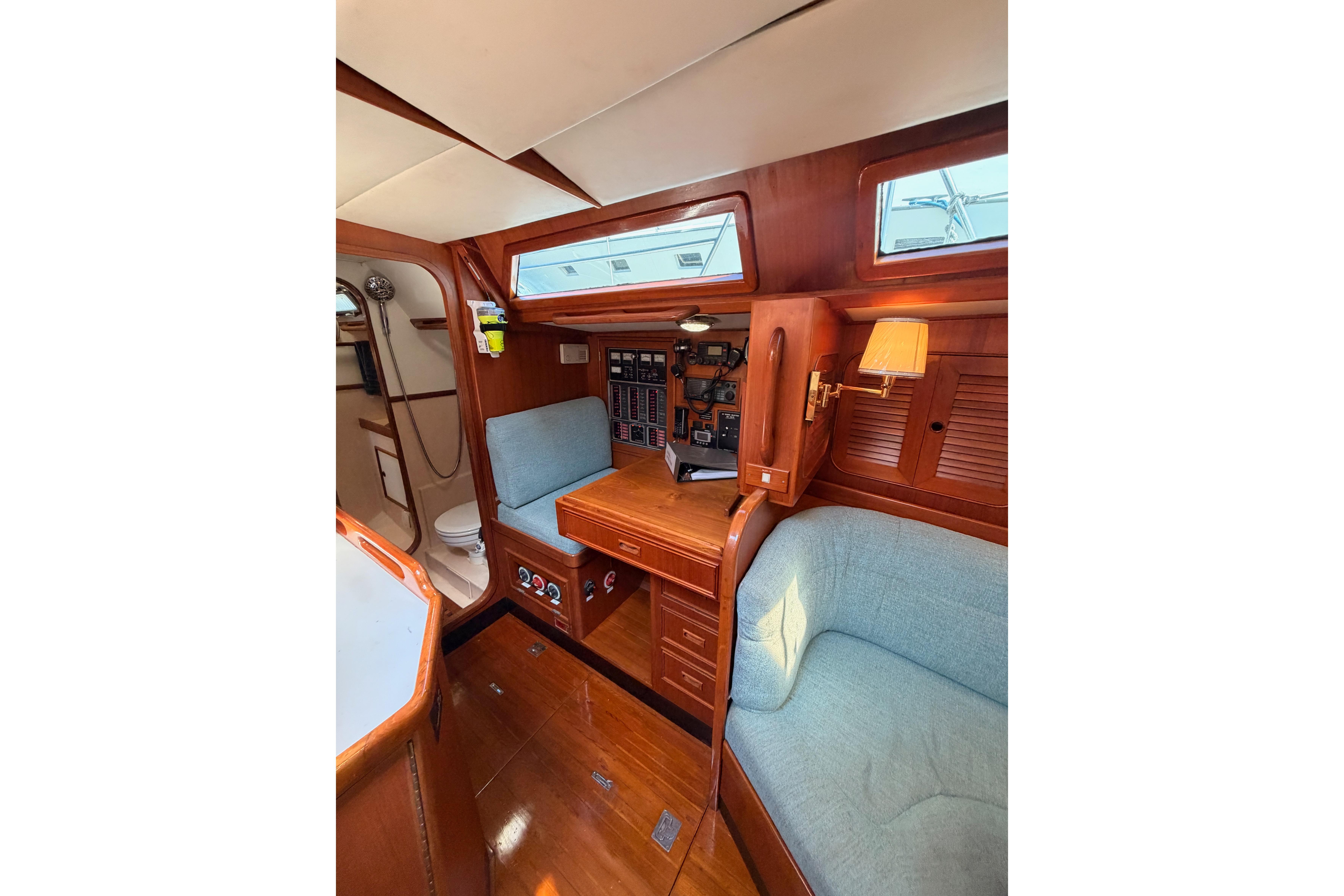 Interior of a 1991 Hylas 51 yacht with wooden furnishings and cozy seating.