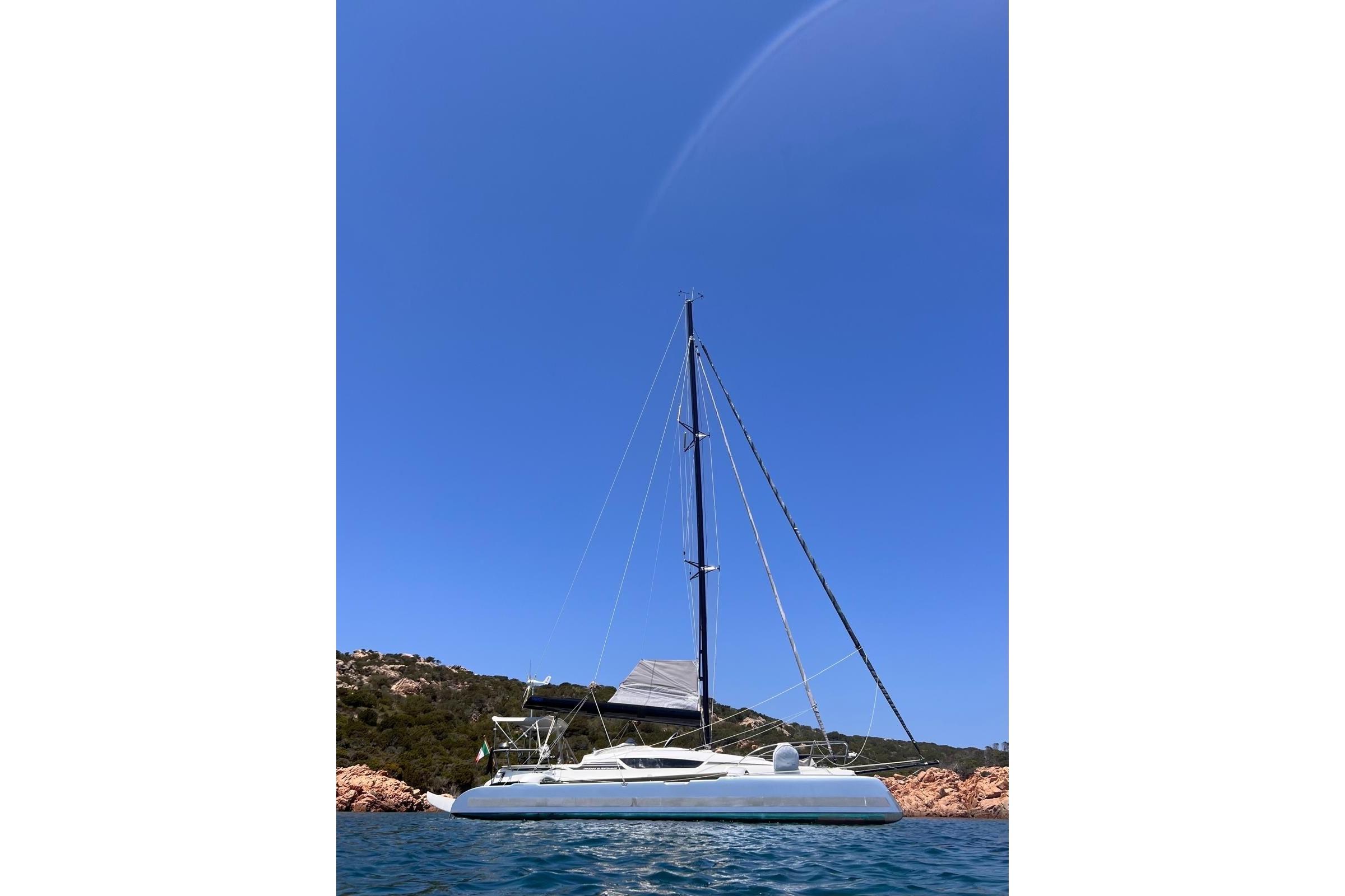 Sailing yacht Dragonfly 28 Performance 2020 on calm blue waters under clear sky.