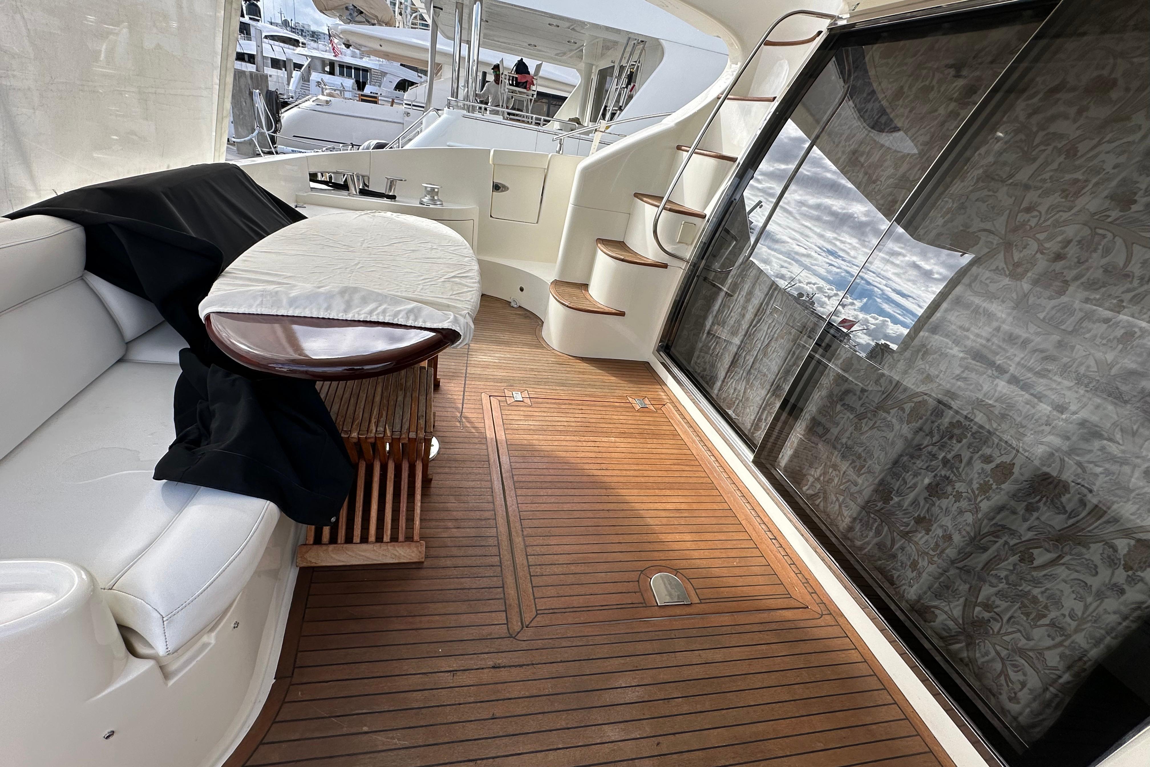 Luxurious 2004 Azimut 55E yacht deck with elegant seating and wooden flooring.