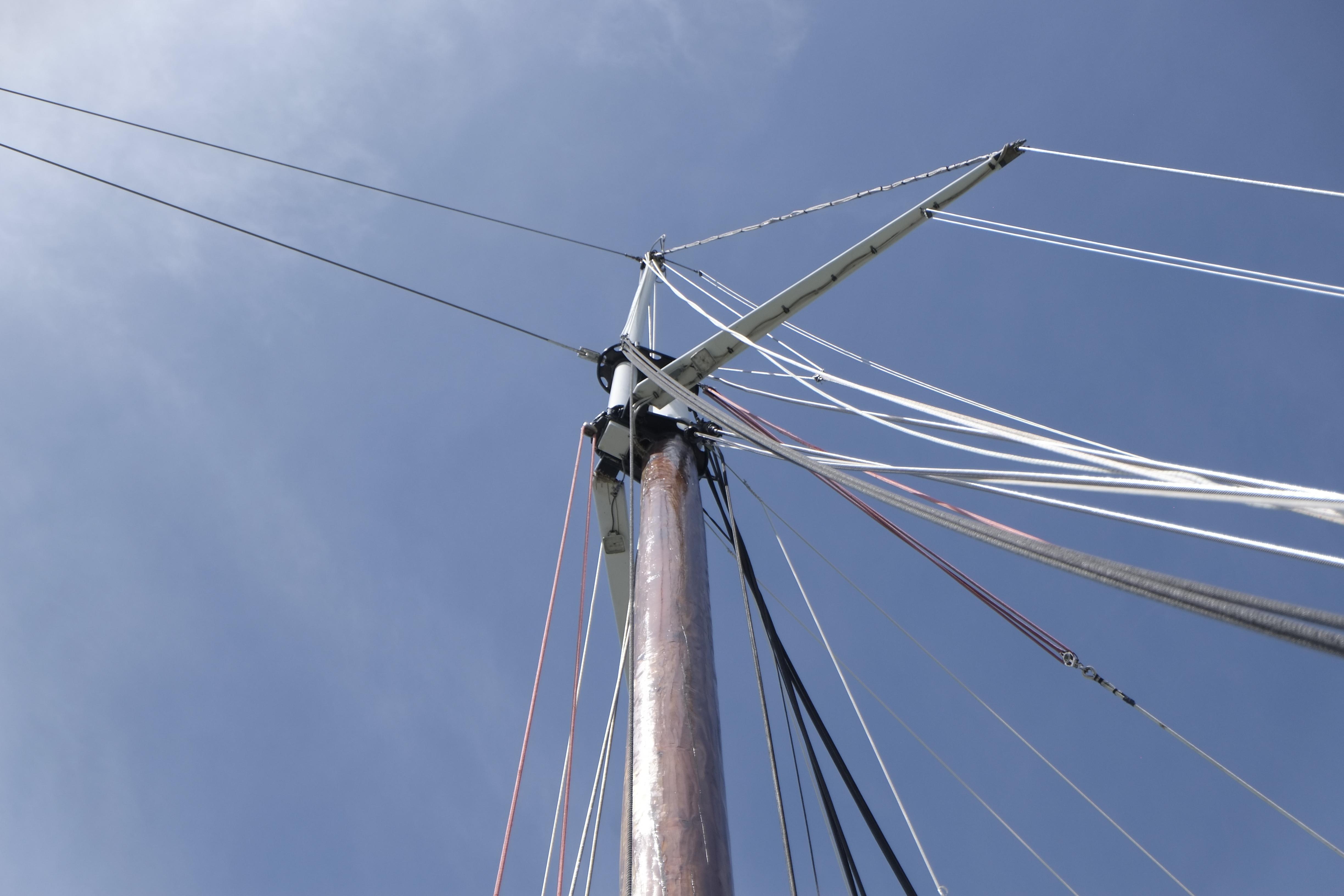 Mast of 2006 Custom Bud Macintosh schooner against clear blue sky.