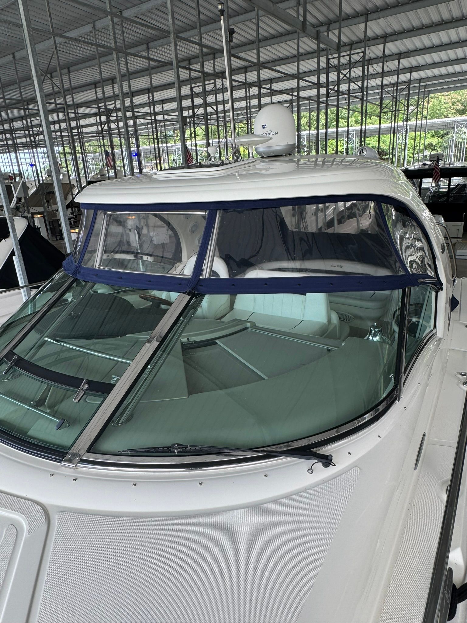 A 2007 Sea Ray 40 Sundancer in a covered dock. It features a blue canopy.