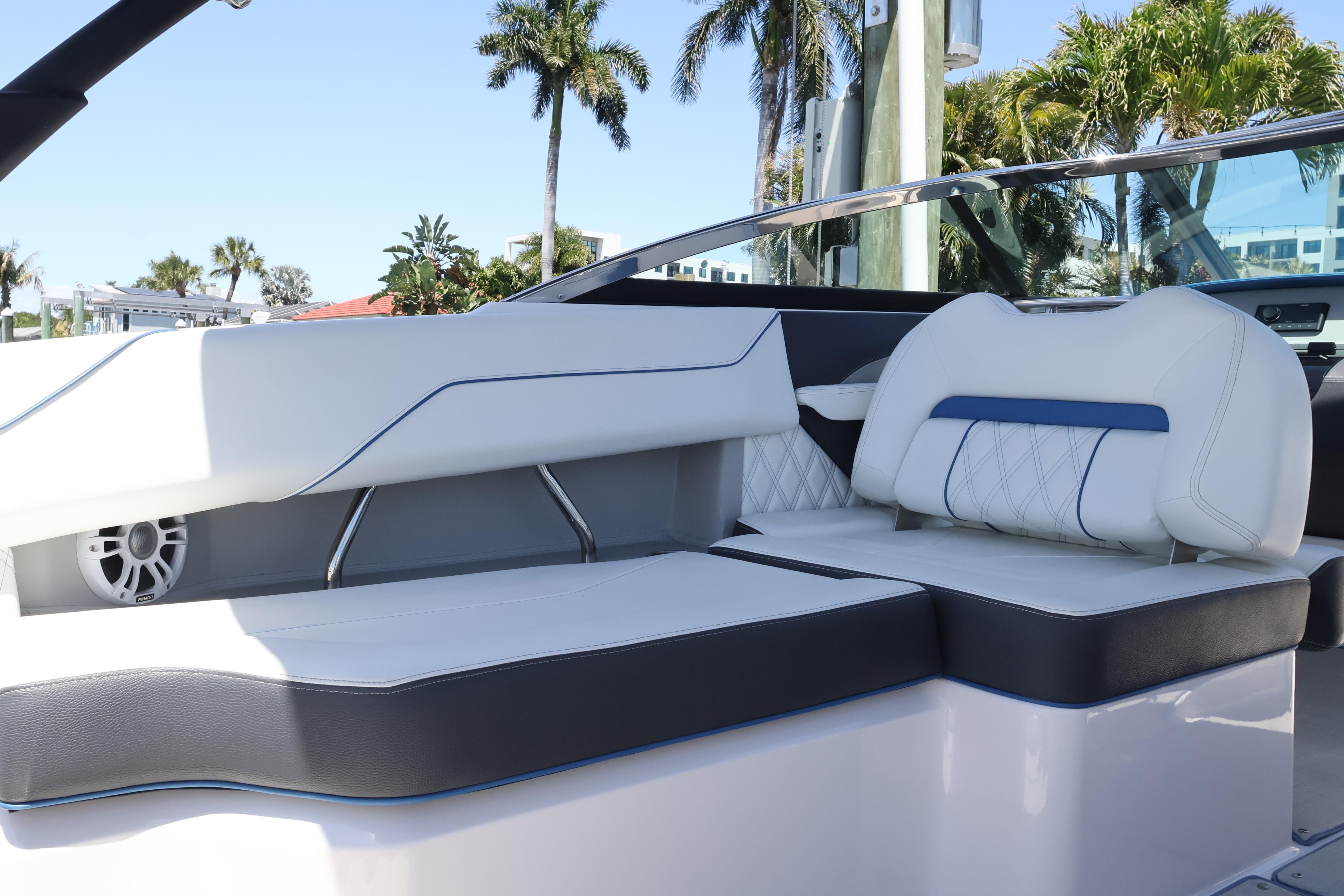 2020 Regal LX4 boat interior with white and blue seating, palm trees in background.