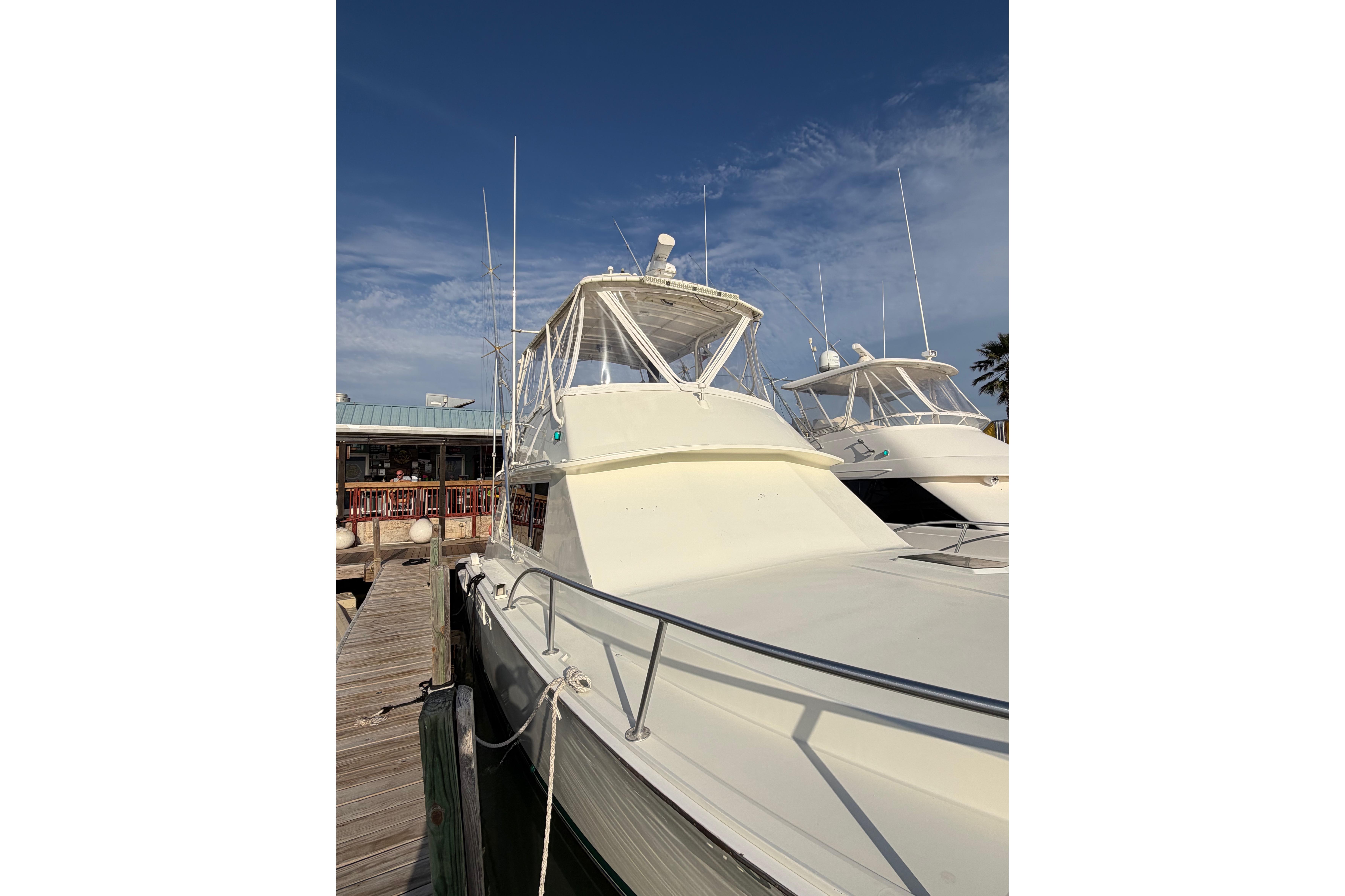 1984 Bertram 42 Convertible yacht docked under a clear blue sky.