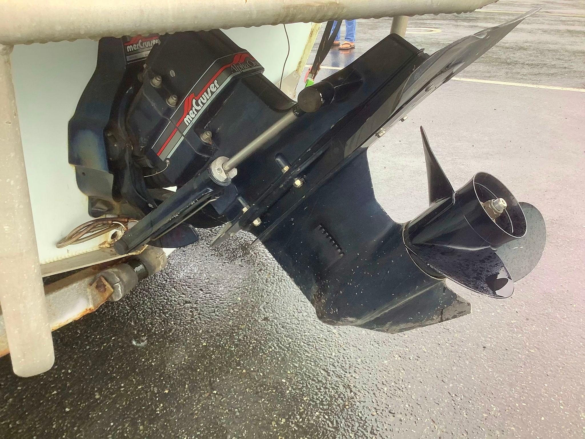 1997 Fish Rite 213 FC boat motor and propeller on wet pavement.