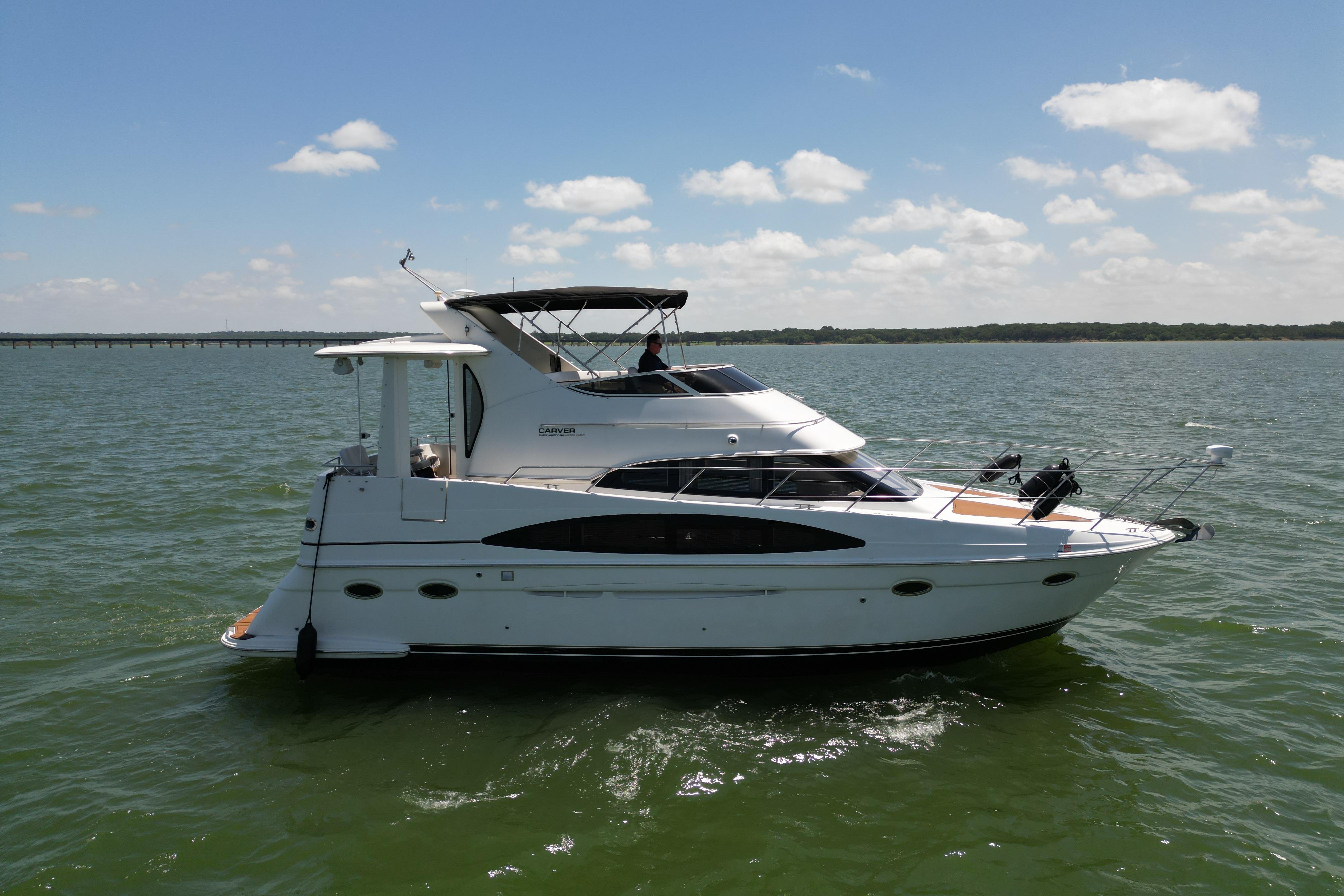 2002 Carver 396 Motor Yacht cruising on a sunny day, surrounded by calm waters.