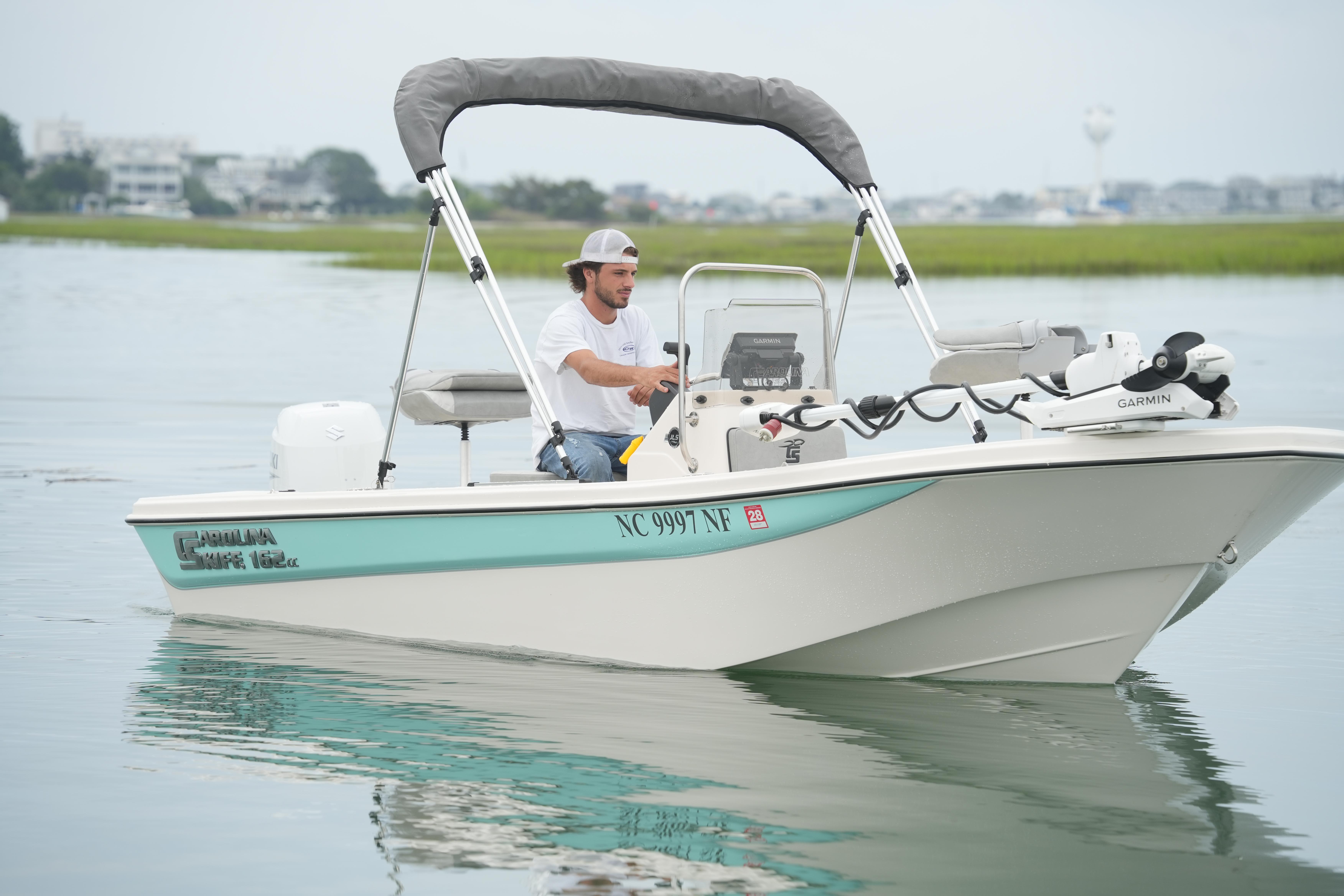2025 Carolina Skiff 162 JLS boat on calm water with a person steering.