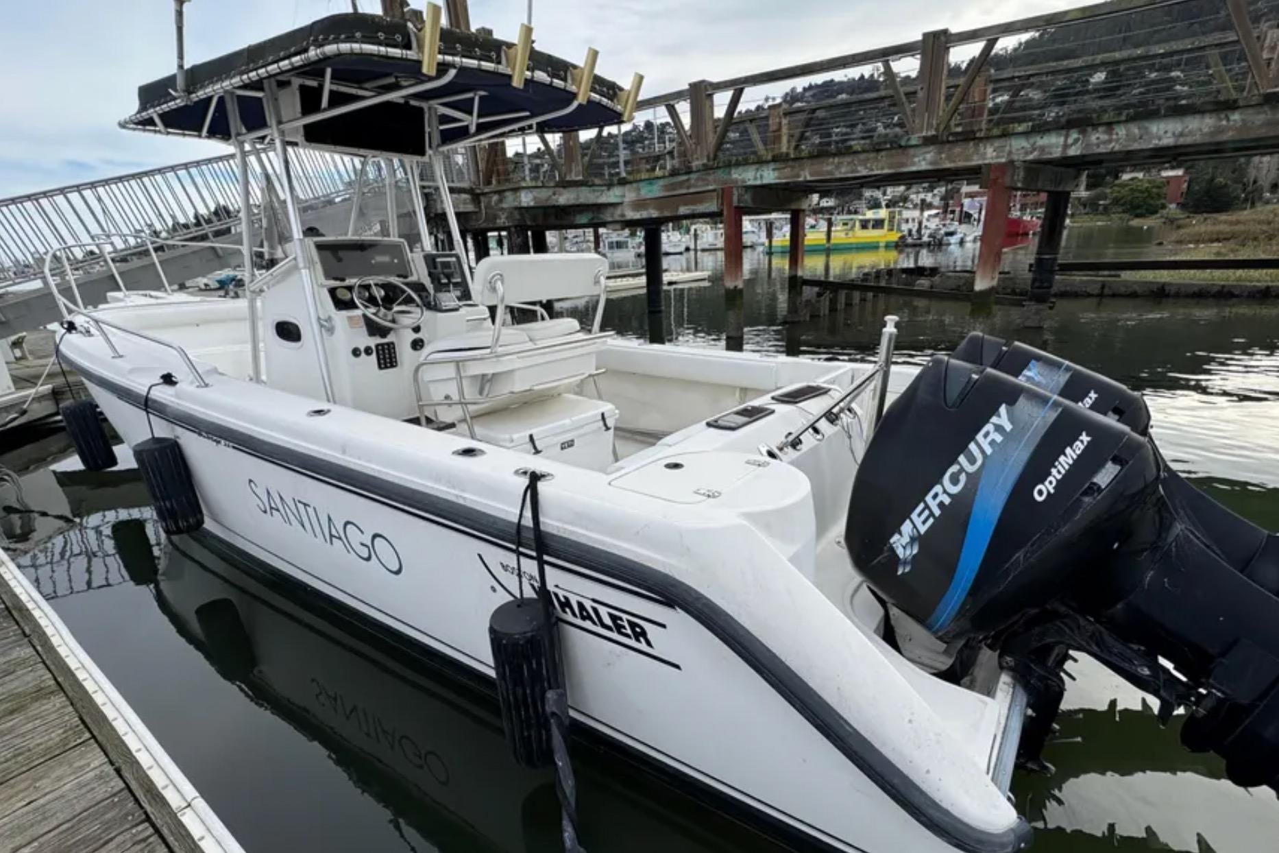 2001 Boston Whaler 26 Outrage boat docked with Mercury OptiMax engines.