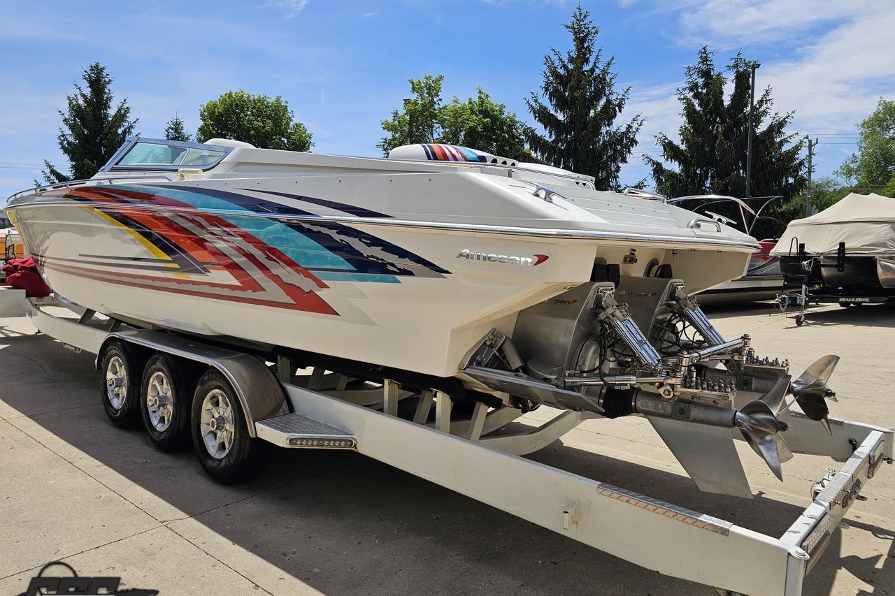 2002 Formula 382 FASTech speedboat on trailer, featuring vibrant graphics and dual propellers.
