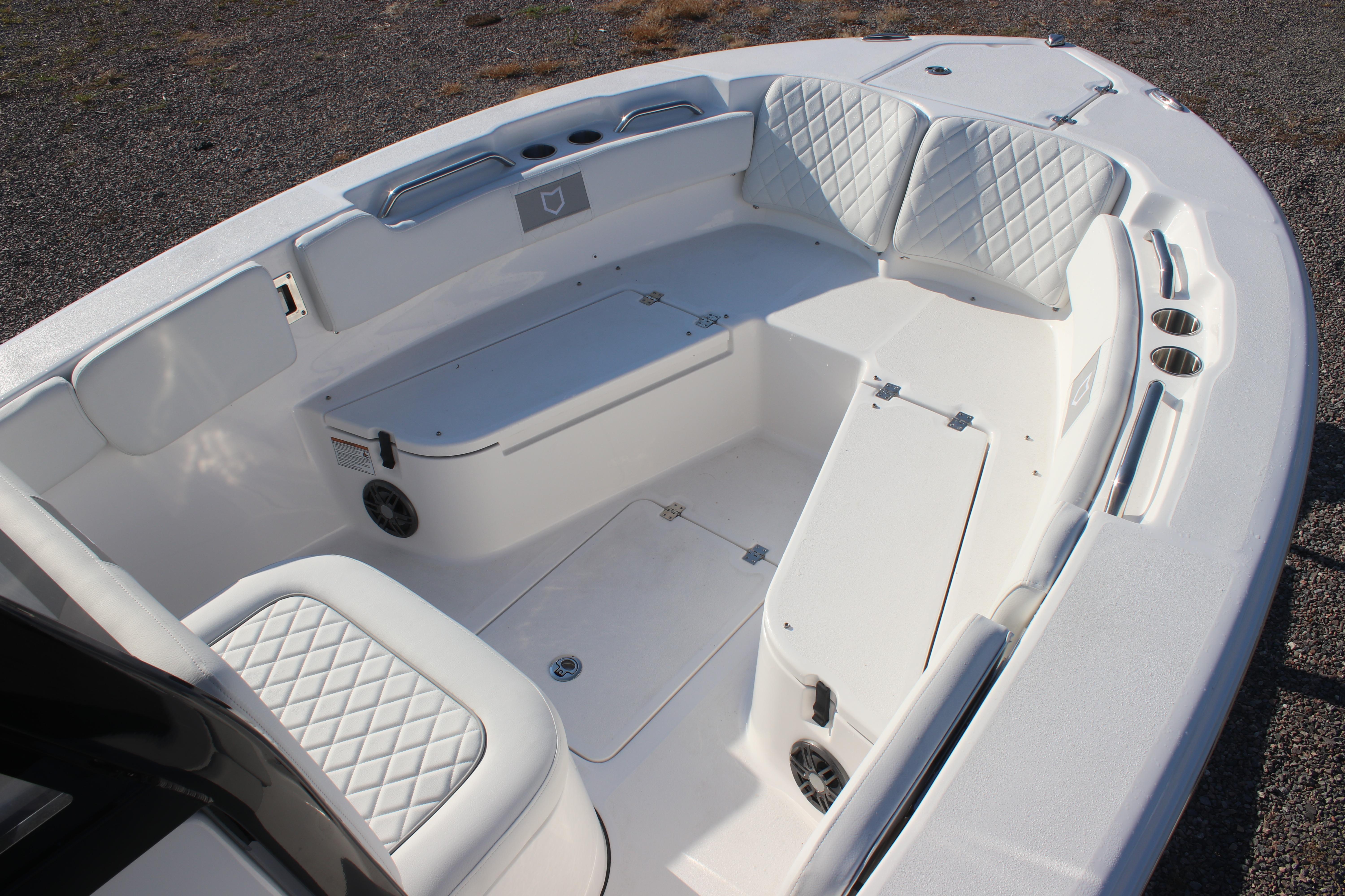 2026 Sea Fox 248 Commander boat interior with white cushioned seating and storage compartments.