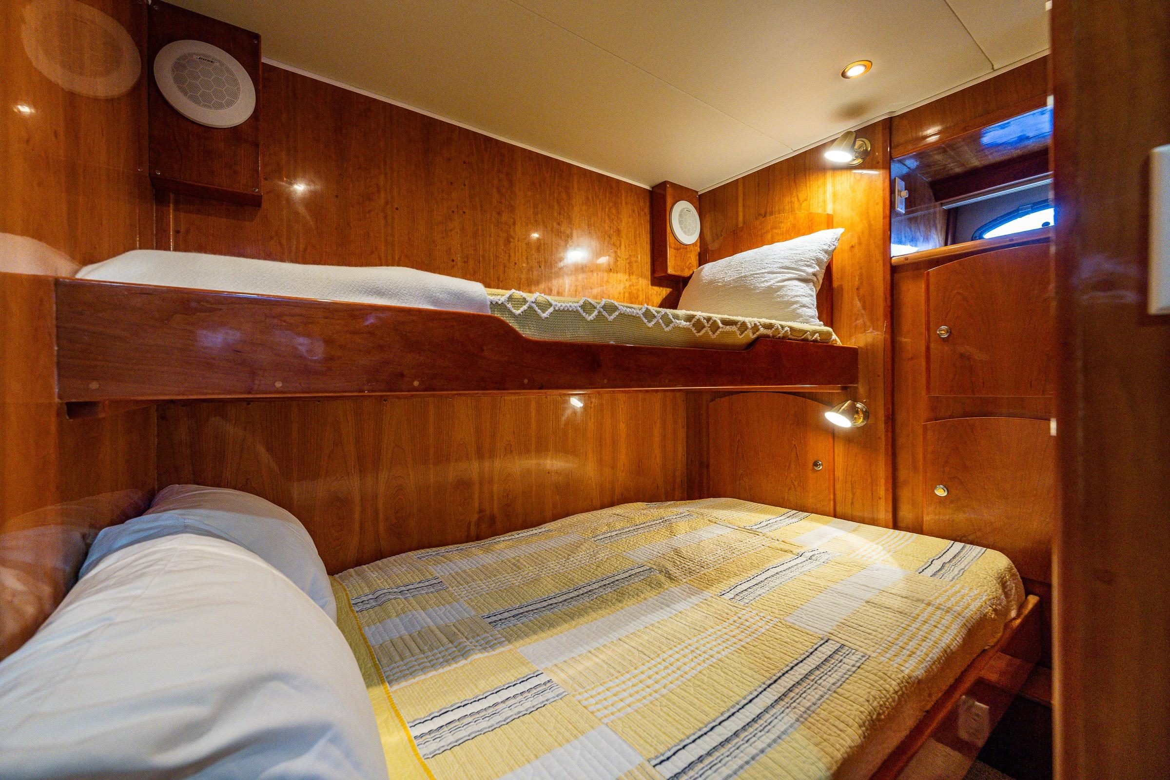 2001 Navigator Pilothouse yacht cabin with wooden bunk beds and cozy lighting.