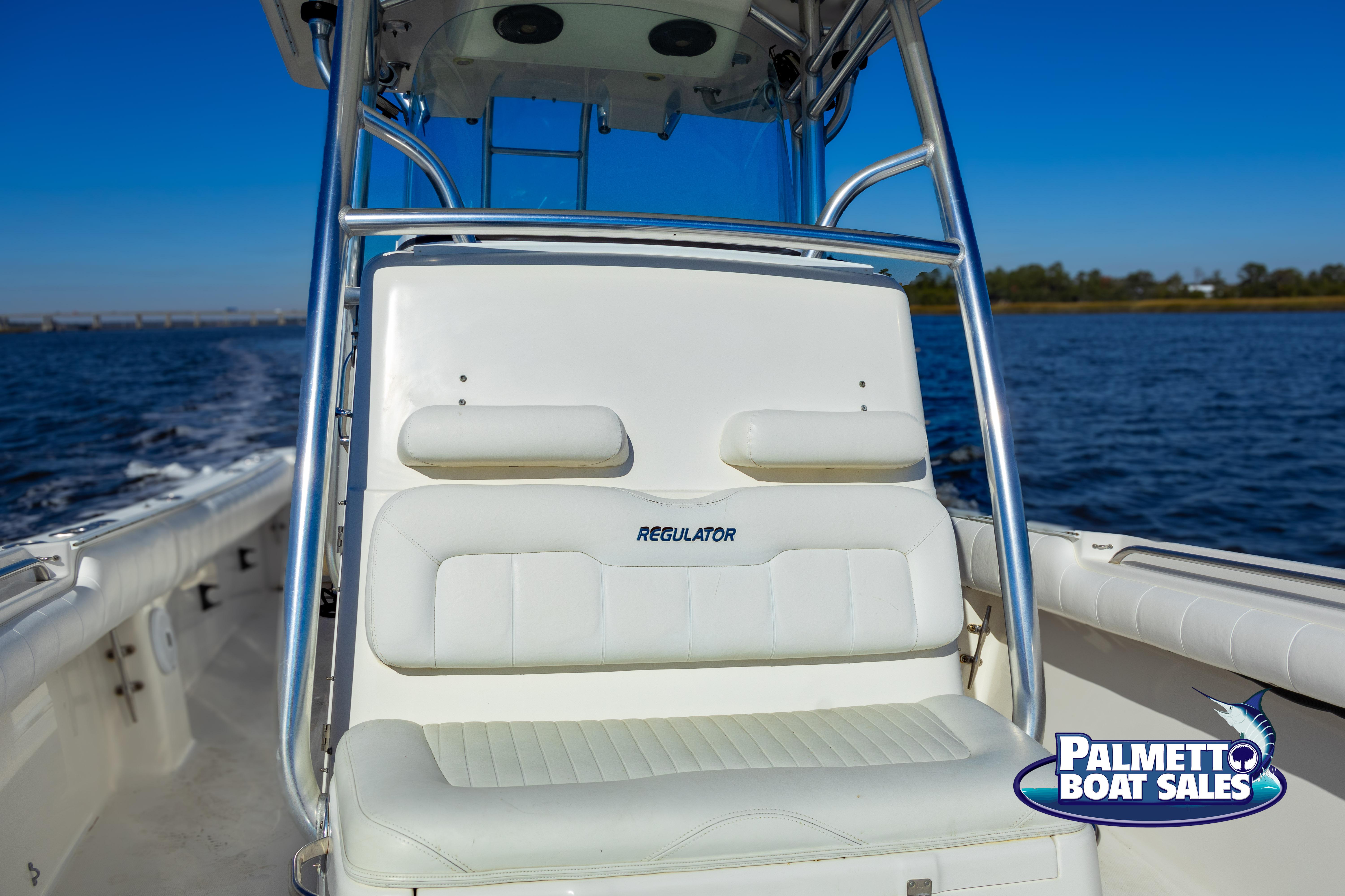 2011 Regulator 28 boat on water, featuring white seating and Palmetto Boat Sales logo.