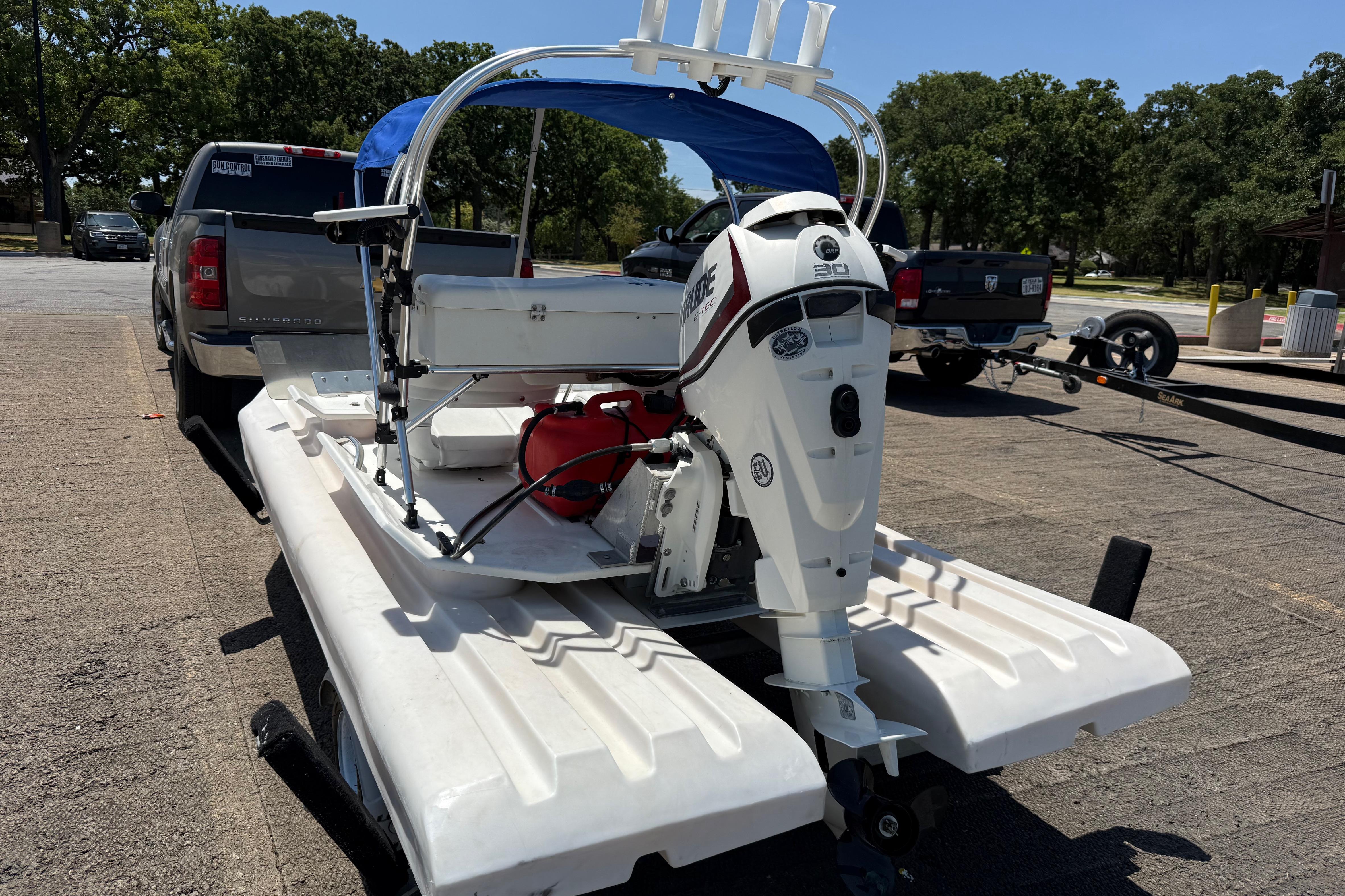 2016 CraigCat E2 Elite catamaran with outboard motor on trailer, parked outdoors.