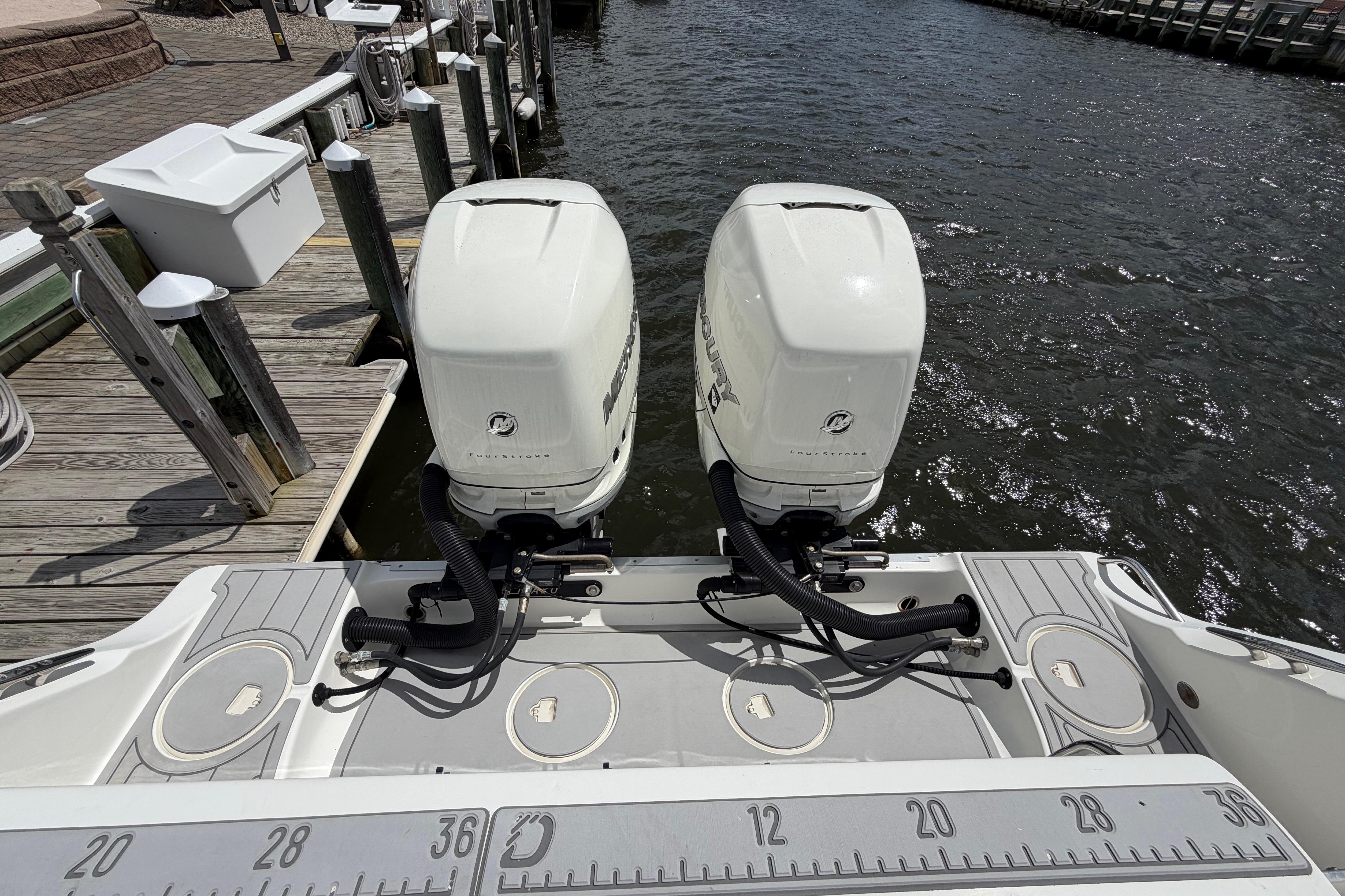 2017 Mako 284 Center Console boat with twin outboard engines docked by the water.
