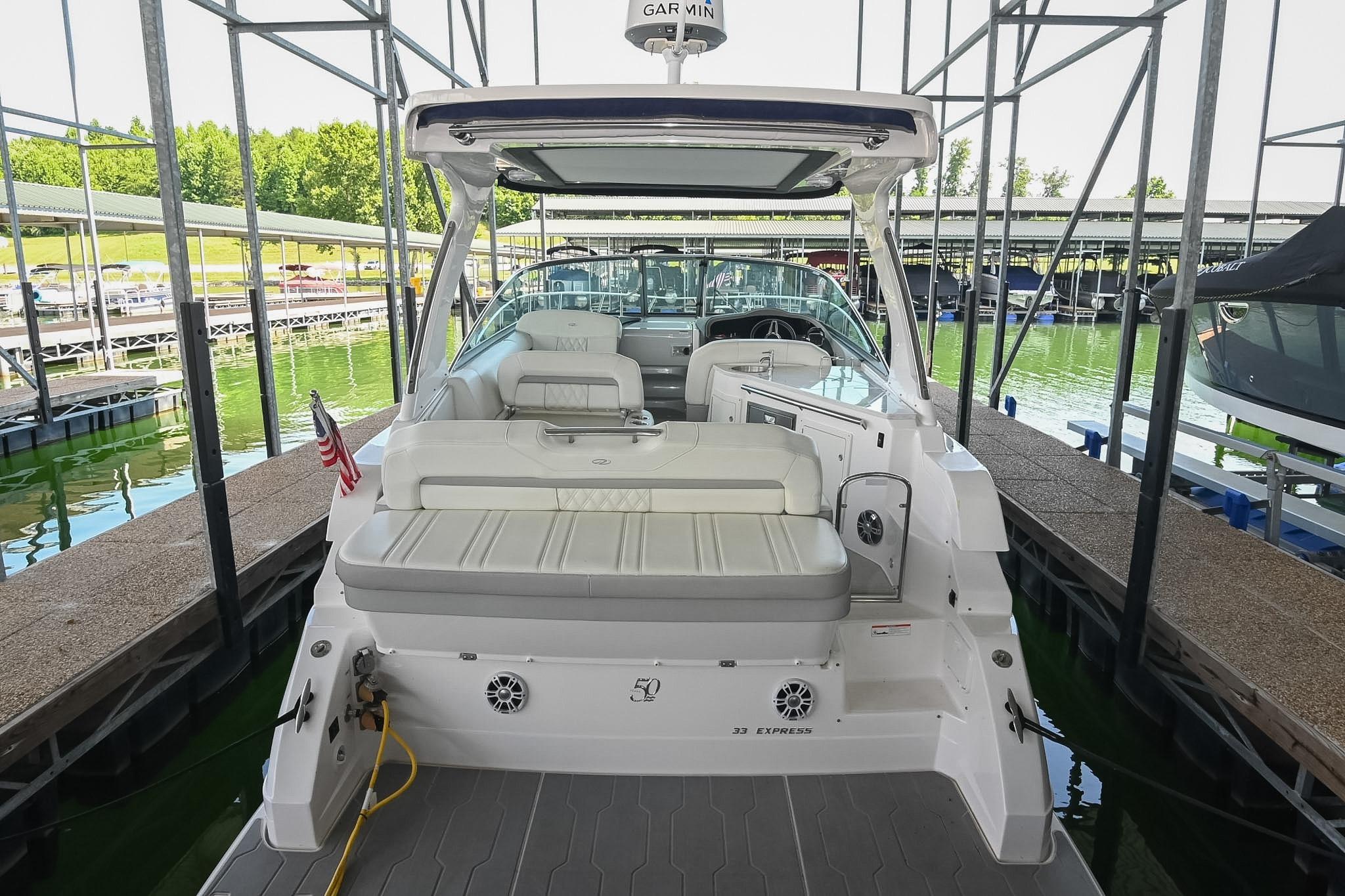 2021 Regal 33 Express boat docked in a marina, showcasing spacious seating and sleek design.