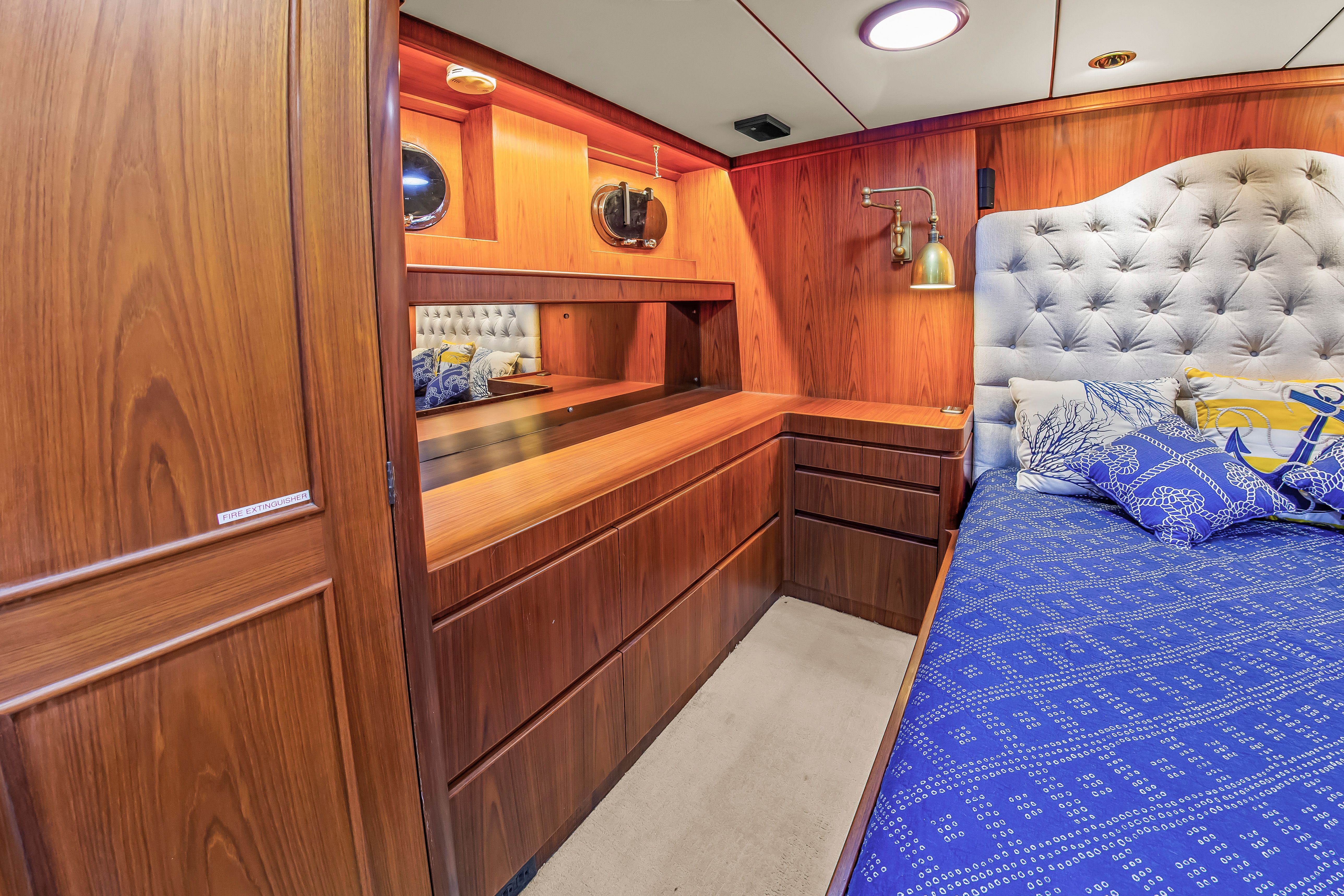 Luxurious cabin with wooden furnishings, a large bed, and elegant lighting.