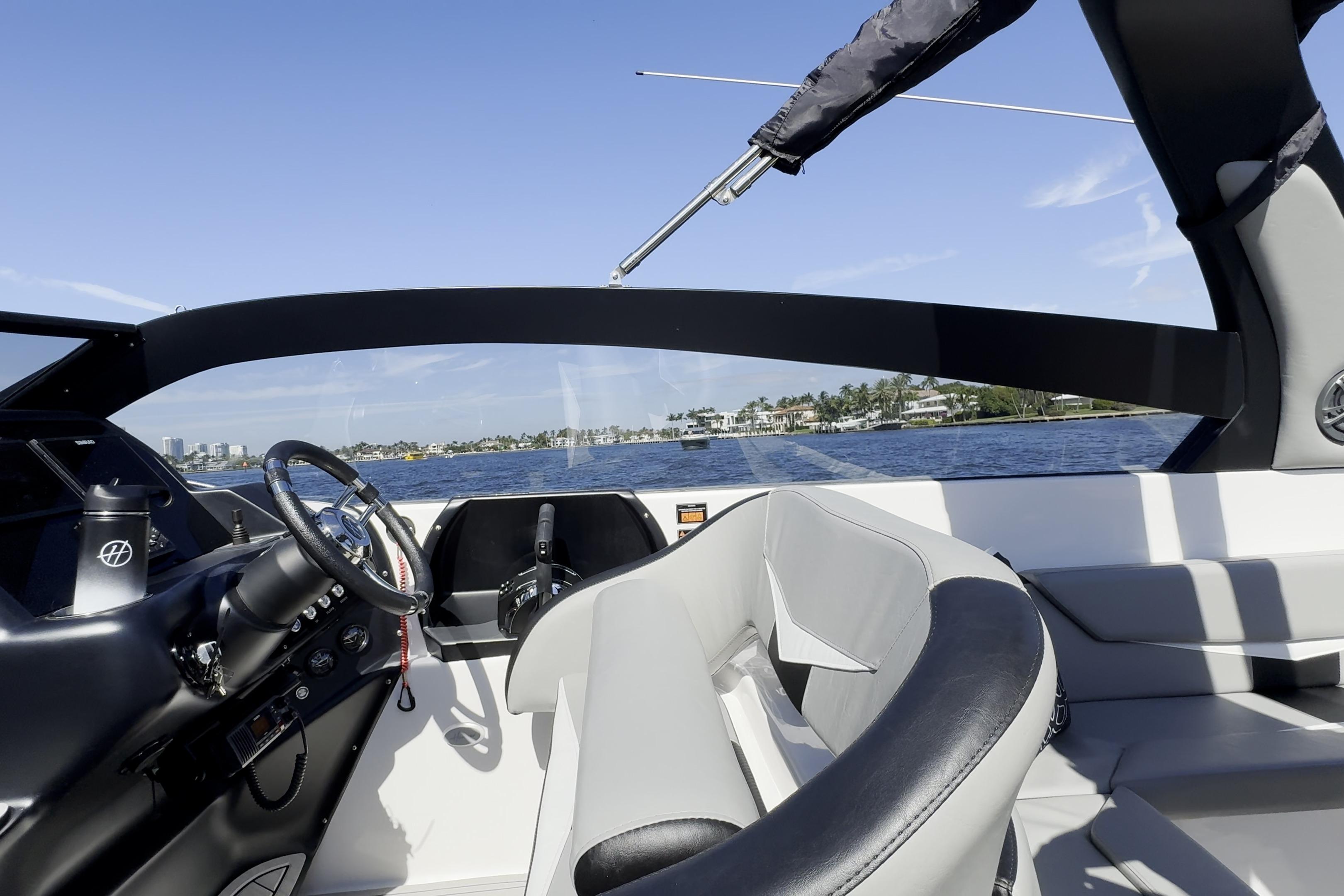 Interior view of a 2027 Hanover 305 boat with steering wheel and seating.