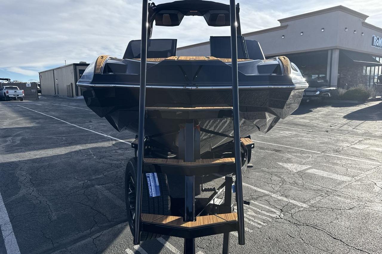 2026 Supra SE 550 boat on trailer in parking lot, rear view.