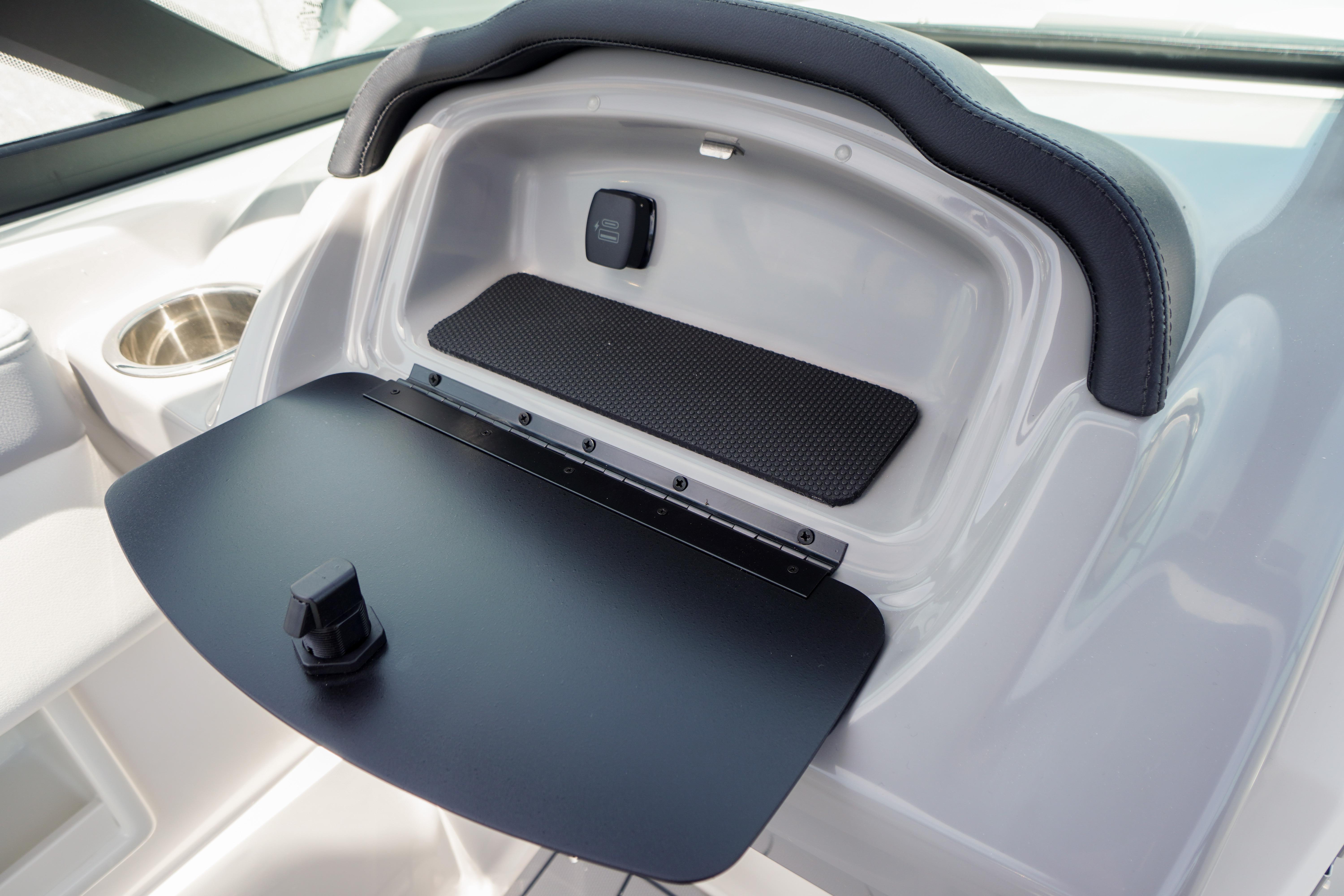 2026 Chaparral 23 SSi OB boat dashboard storage compartment with cup holder and sleek design.