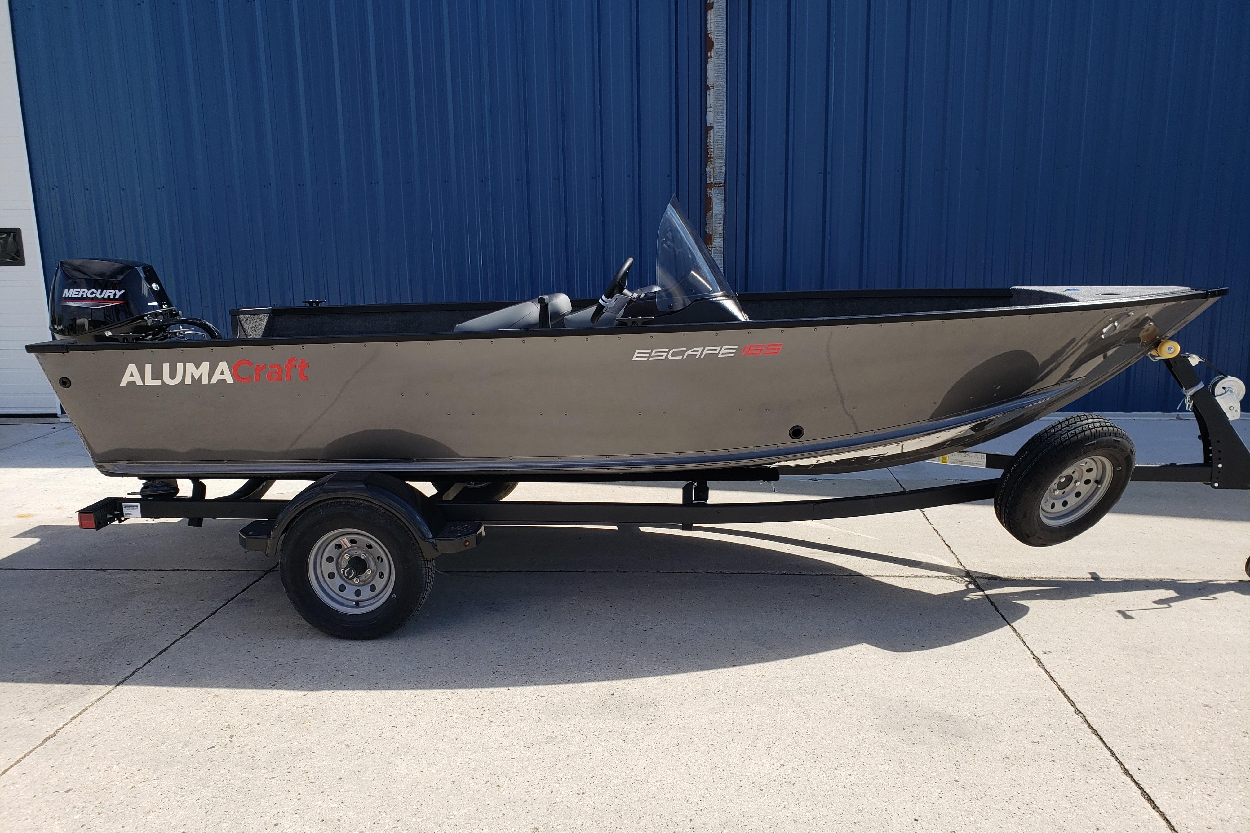 2026 Alumacraft Escape 165 CS boat on trailer, parked outdoors.