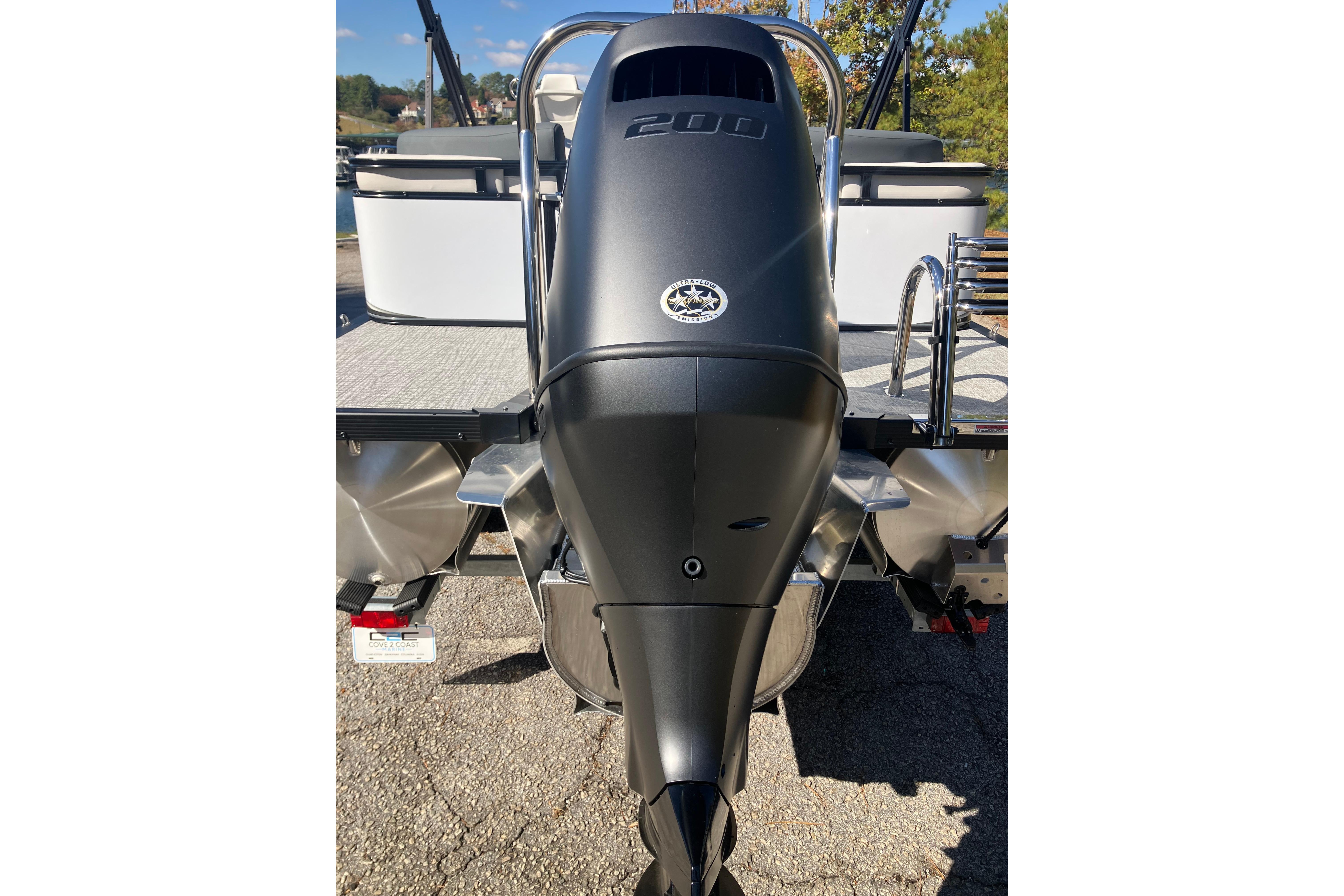 2026 Tahoe Pontoon LTZ Quad Lounger with powerful outboard motor, rear view.