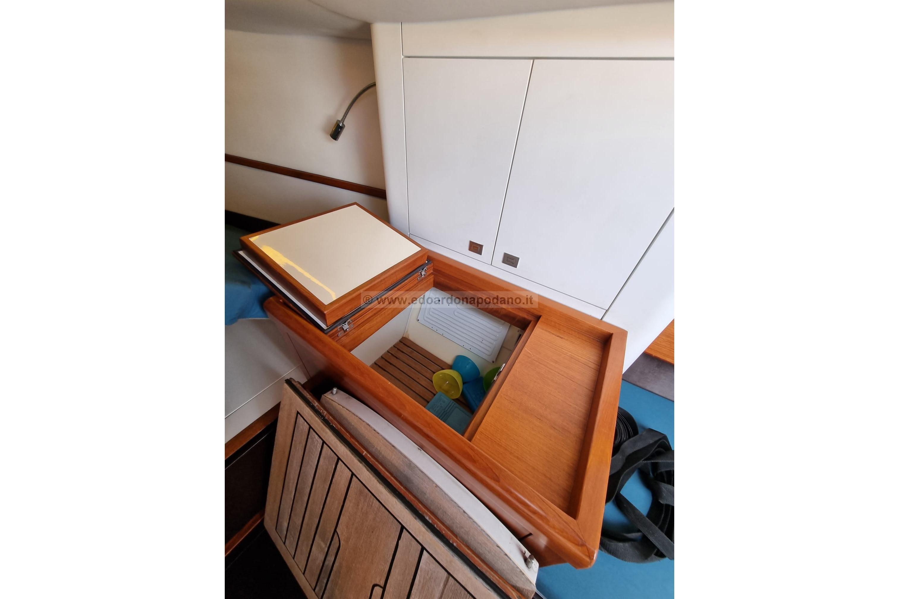 Interior of 2014 Essence 33 yacht with wooden cabinetry and storage compartments.