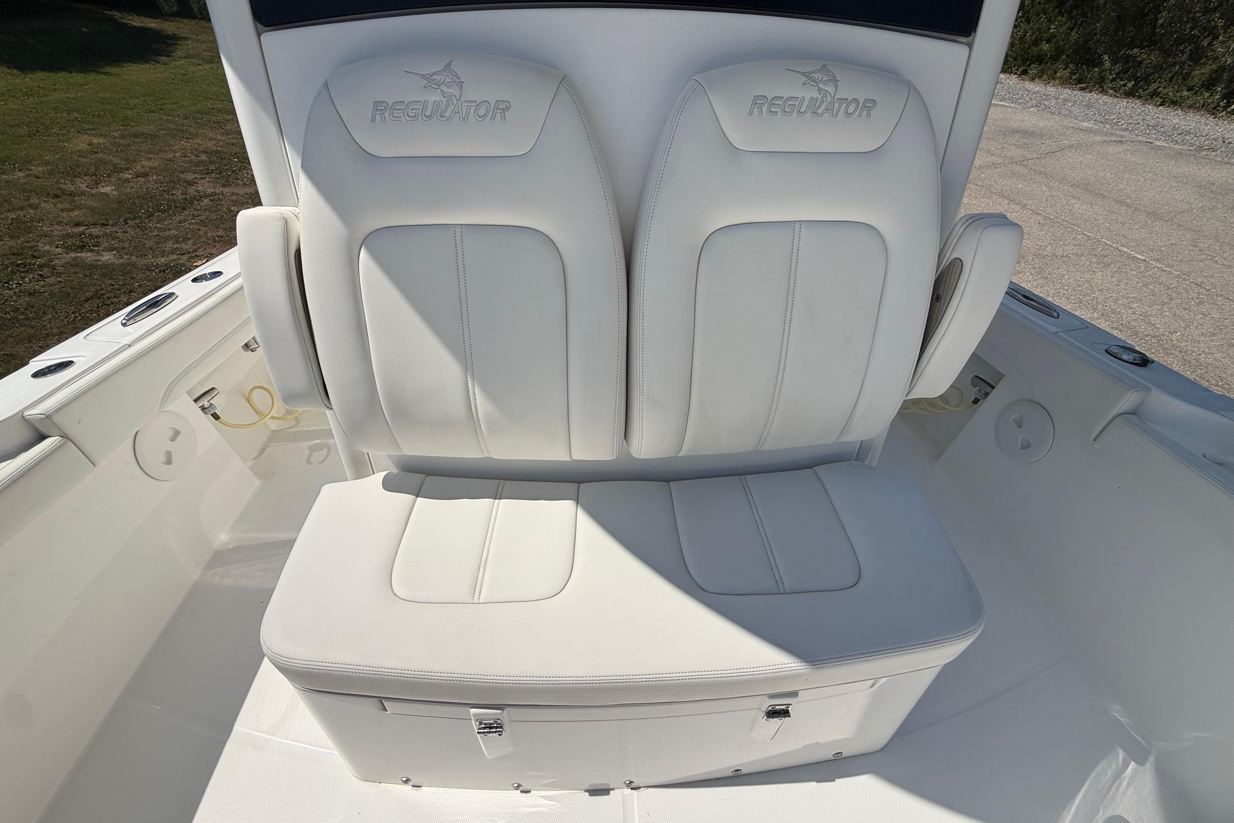 2023 Regulator 26XO boat seating with white cushioned seats and storage compartment.