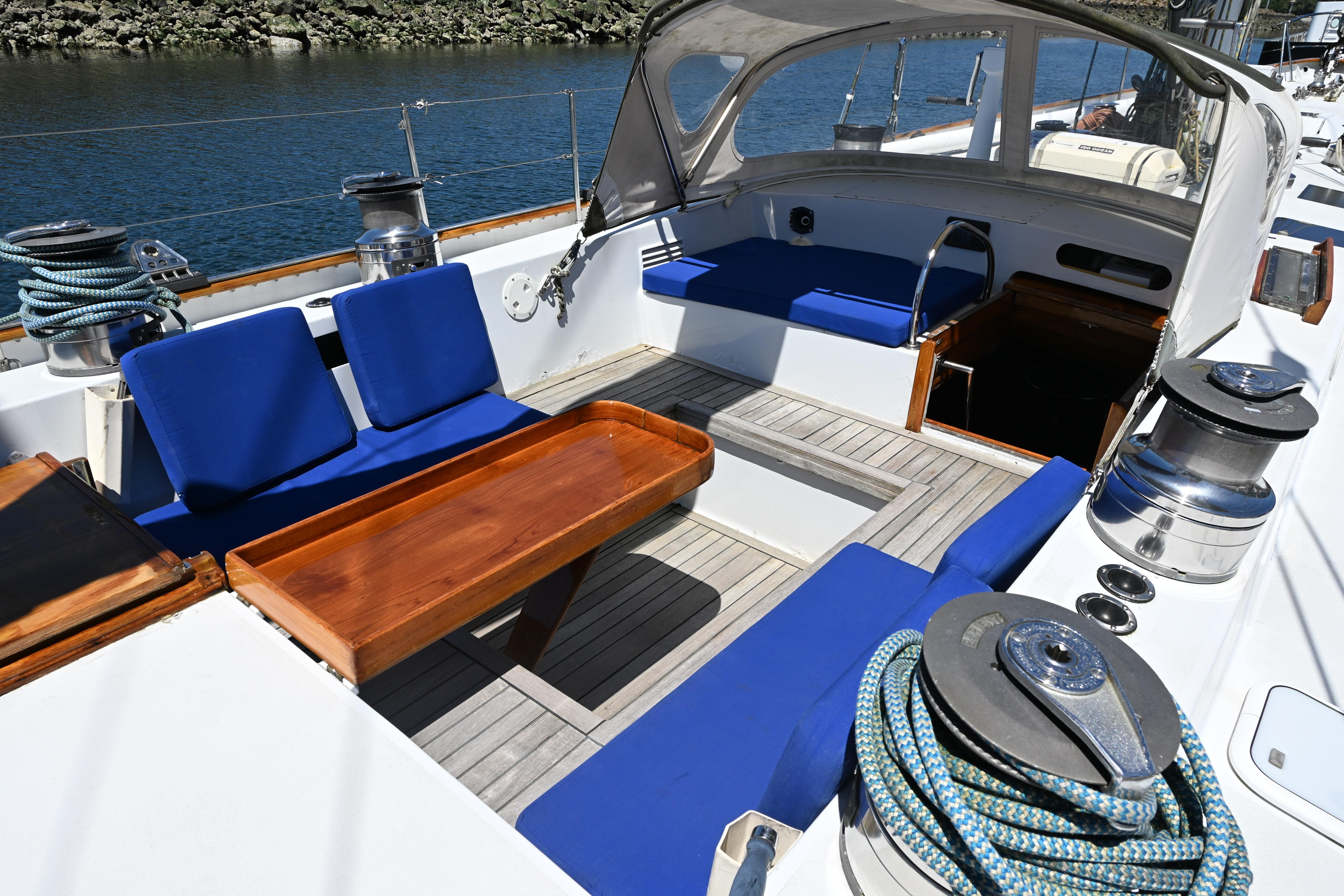 Cockpit of 1968 Abeking & Rasmussen Tripp 74 yacht with blue seating and wooden table.