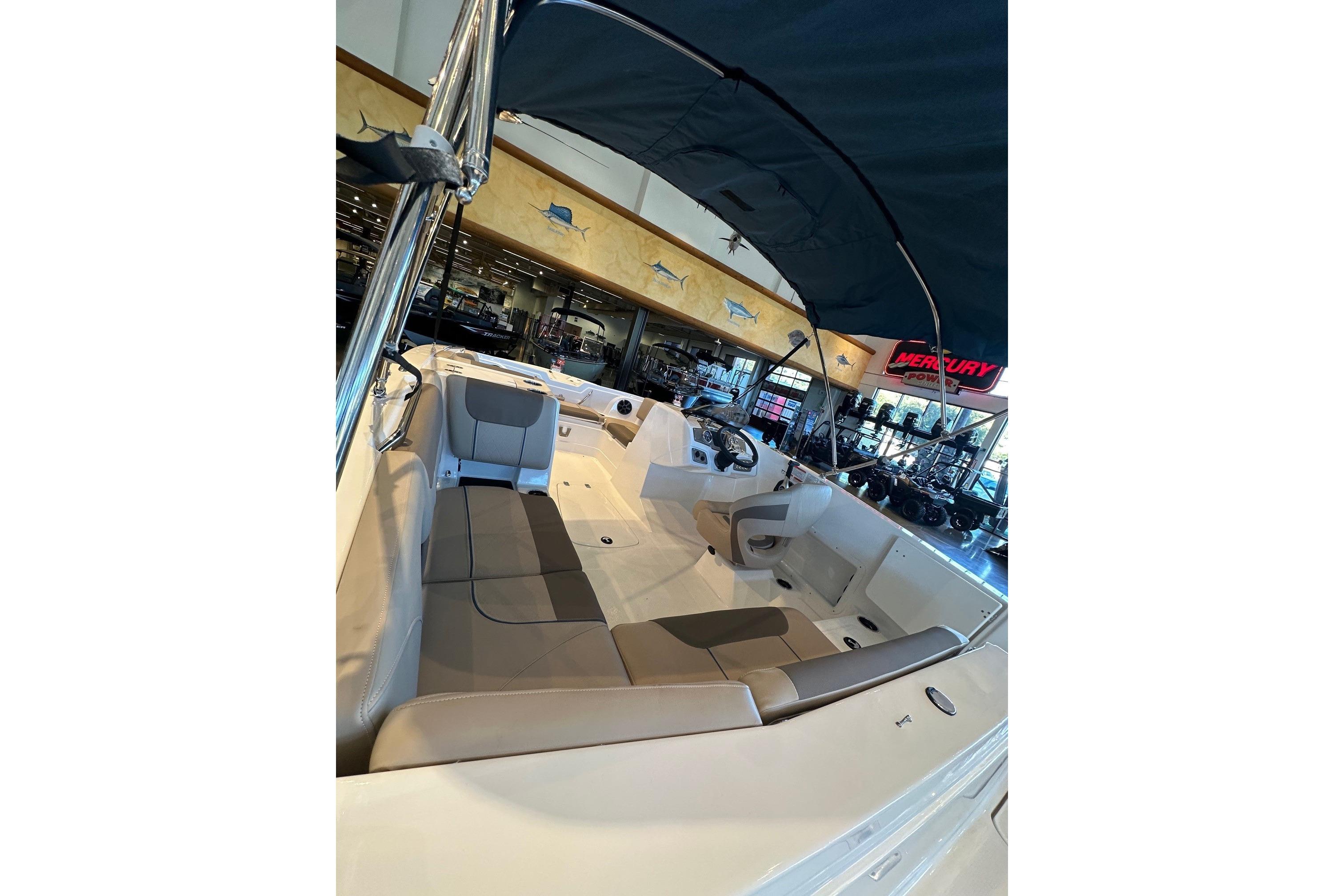 2026 Tahoe 1950 boat interior with seating and canopy in showroom.