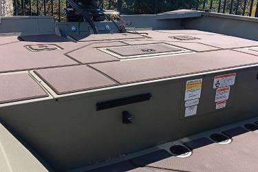 2026 Tracker Grizzly 2072 CC boat deck with storage compartments and safety labels.