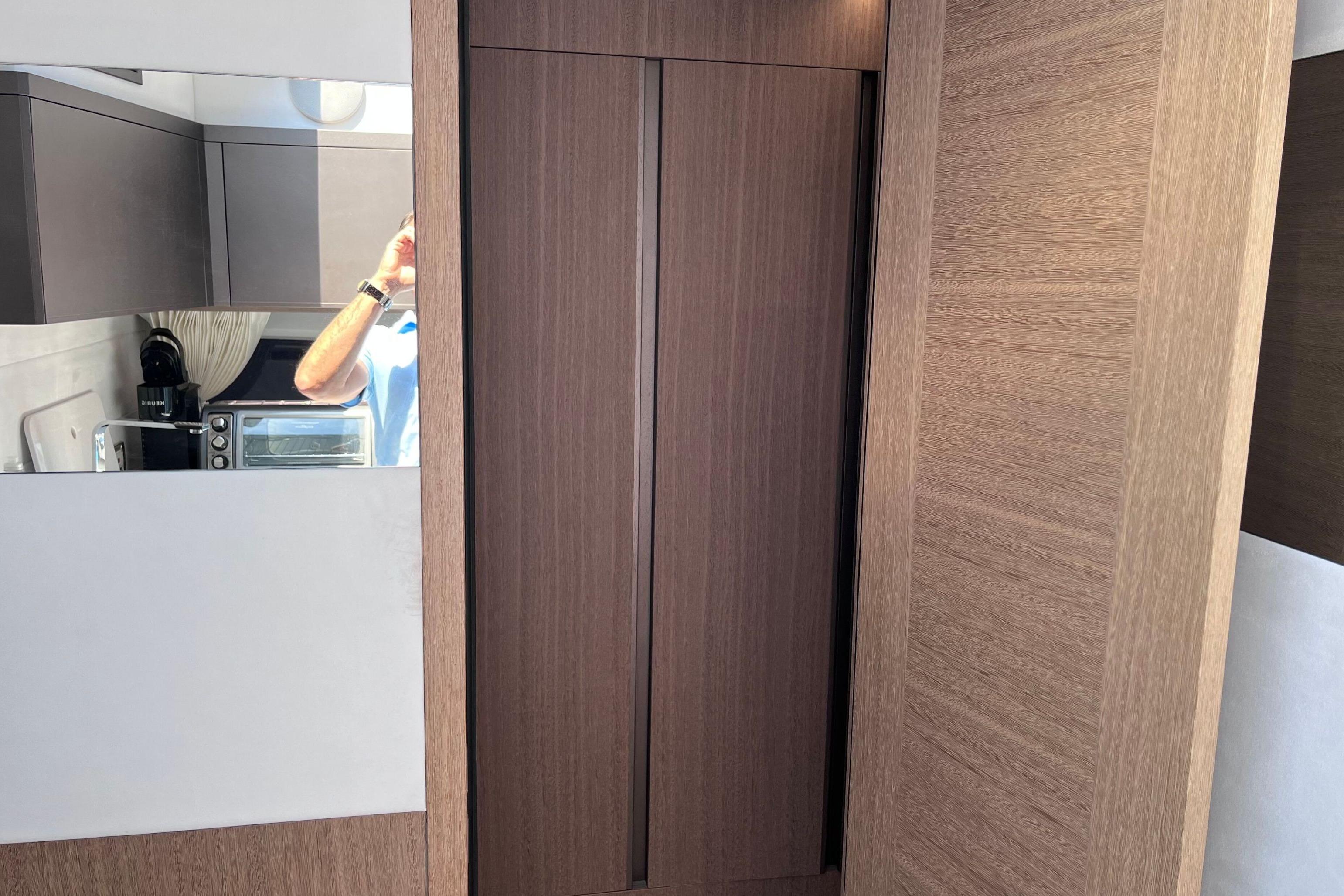 Interior of 2024 Galeon 425 HTS yacht with modern wood paneling and kitchenette.