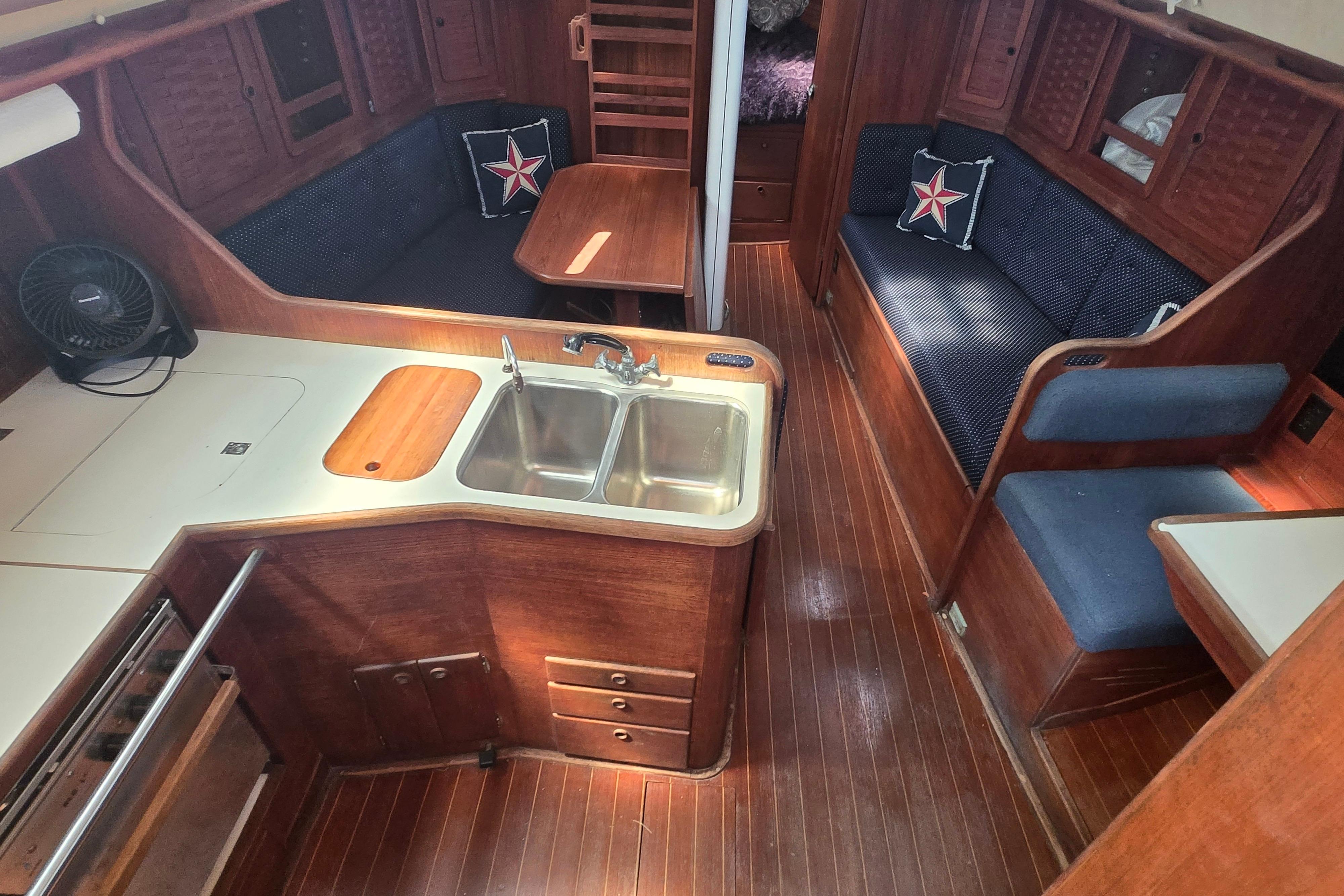 Interior of 1988 Sabre 38 sailboat with wooden cabinetry and cozy seating area.