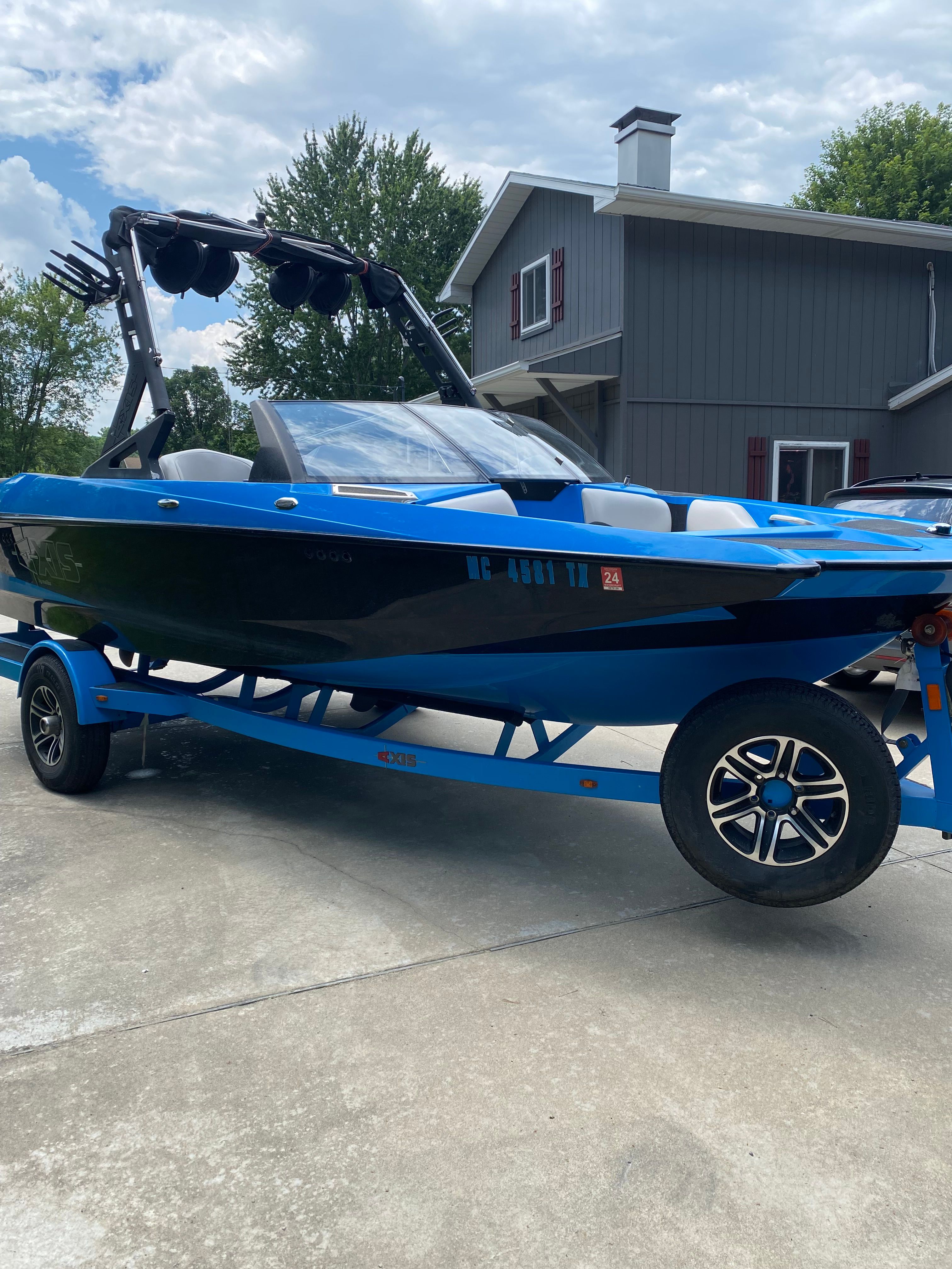2015 Malibu Axis A20 boat on trailer in front of house.