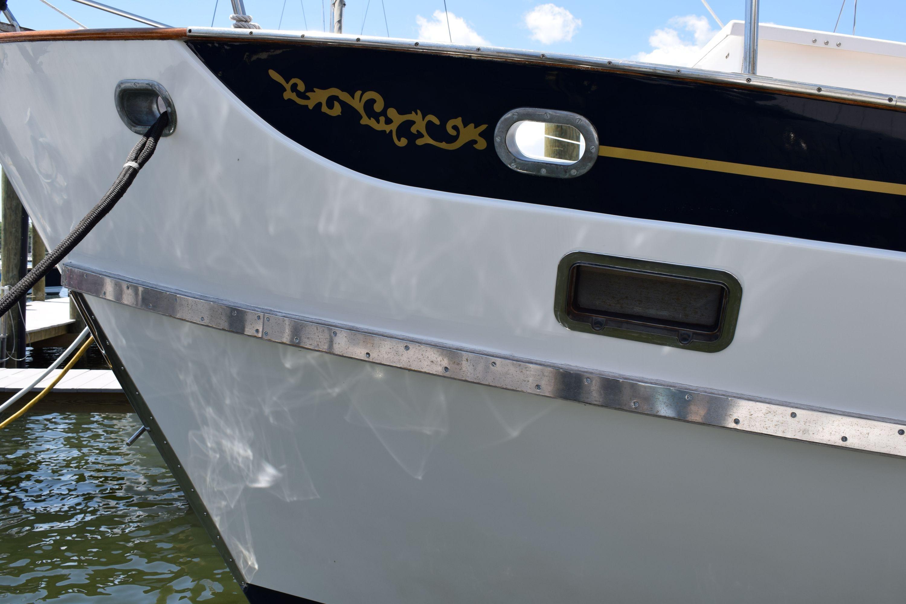 1980 Cheoy Lee 52 Motorsailer boat hull with decorative trim and porthole.