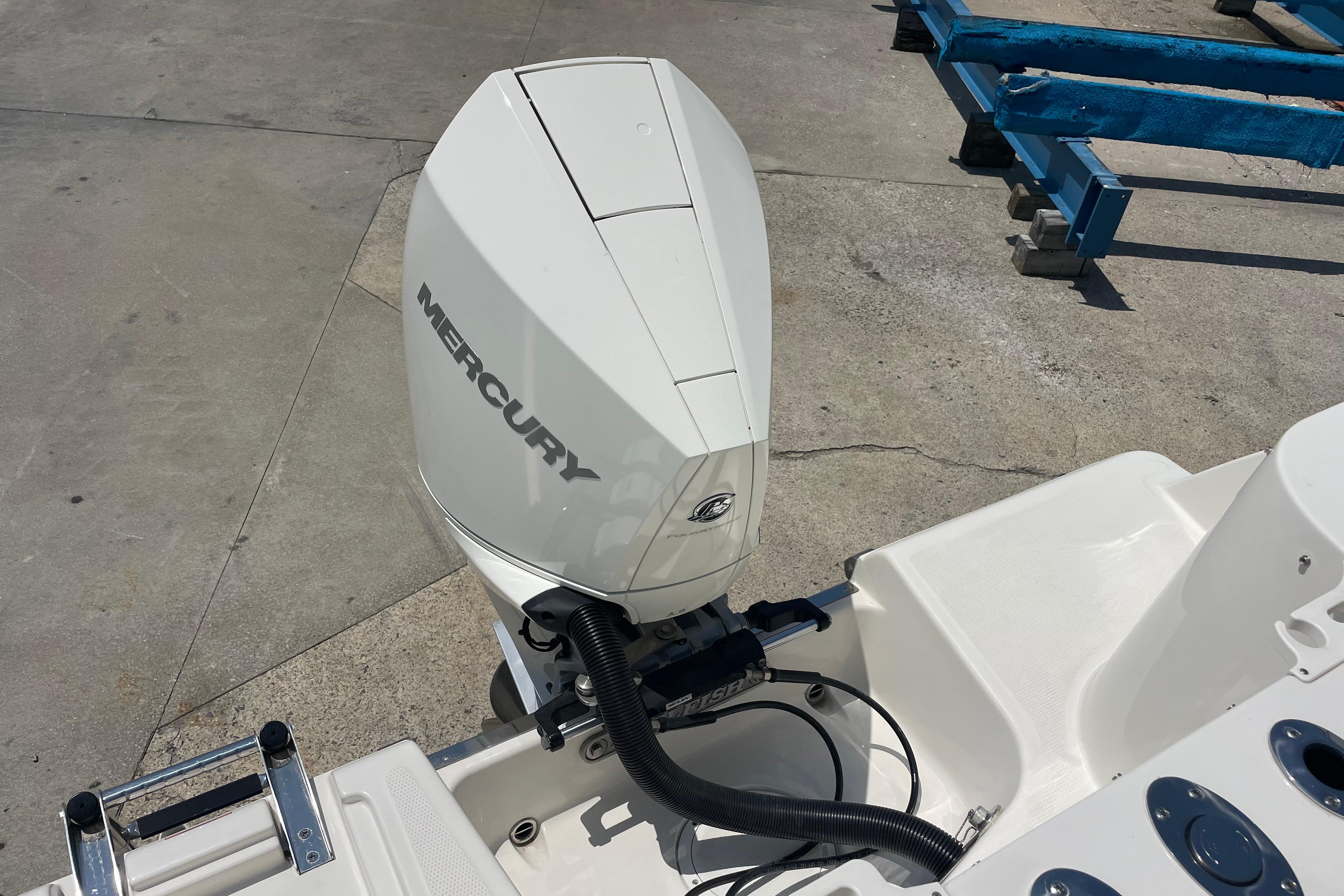 2022 Sailfish 245 DC boat with Mercury outboard motor on a concrete surface.