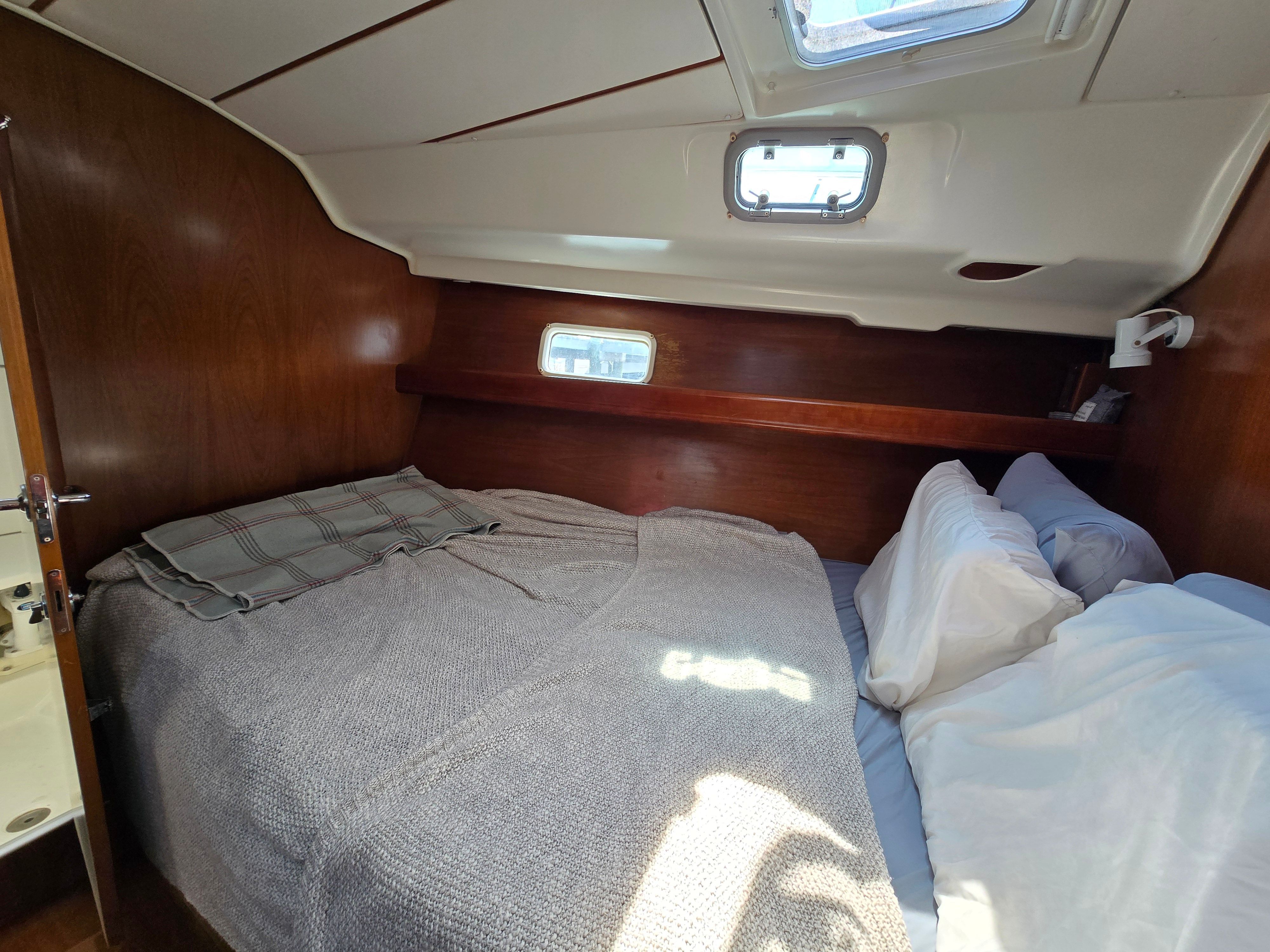 Cabin with double bed, wooden walls, and skylights.